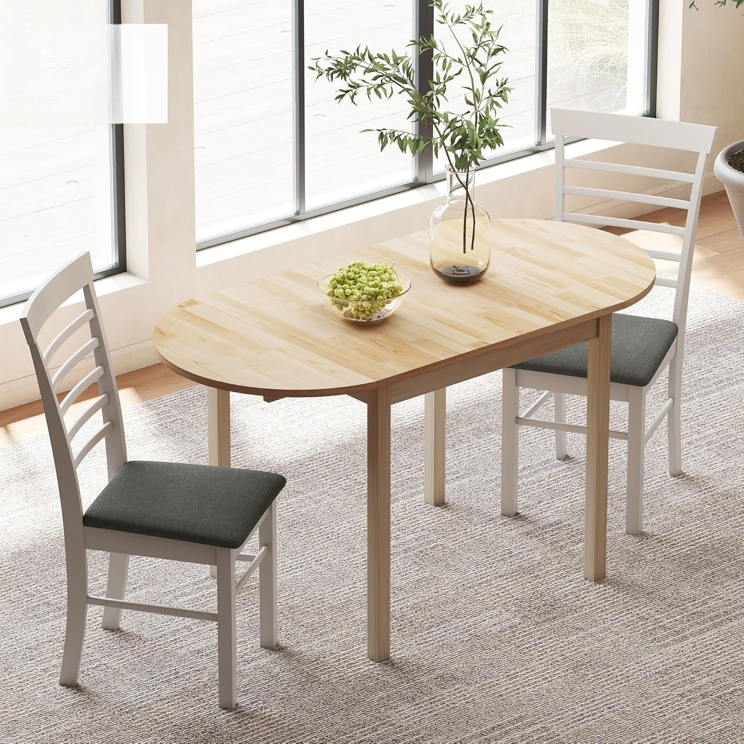 Natural pine folding drop-leaf dining table with two white chairs in a bright styled dining room