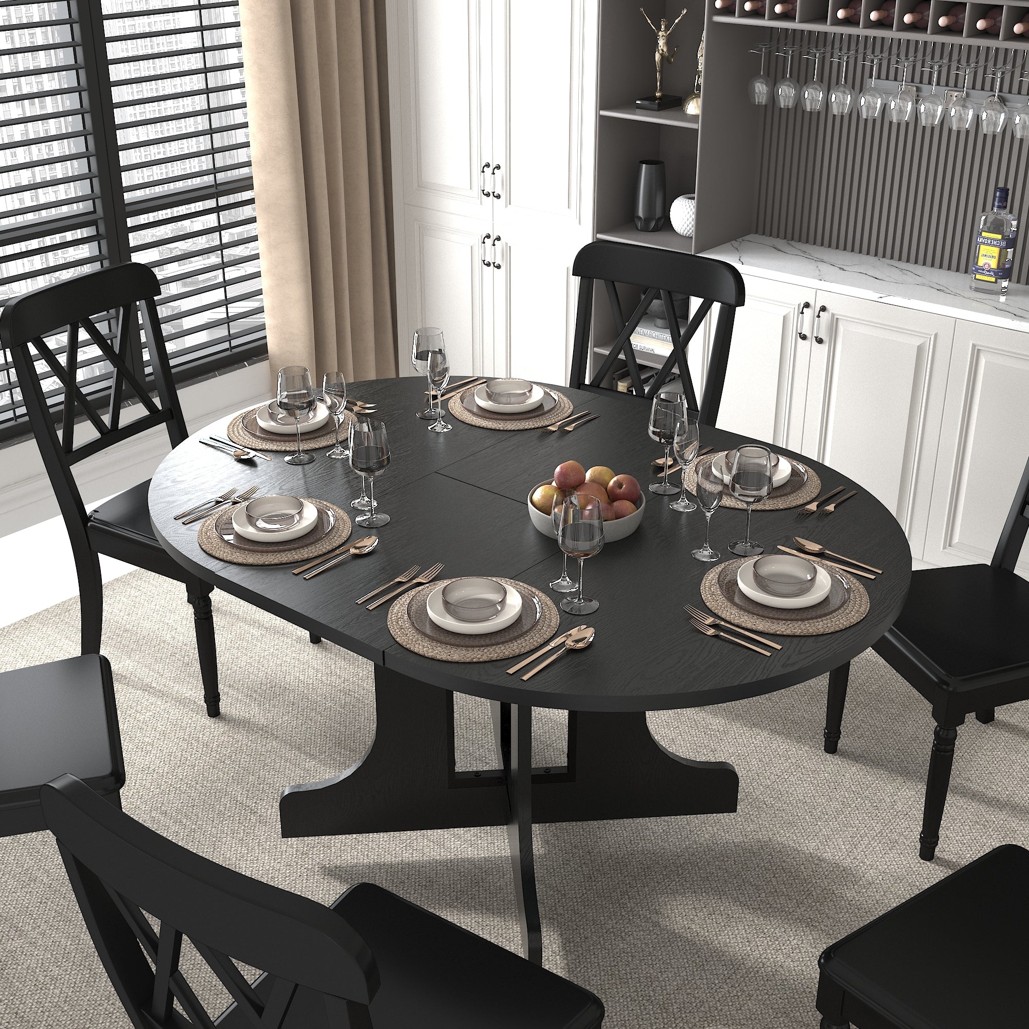 Overhead view of the oval black table set with placemats, plates, wine glasses and a fruit bowl