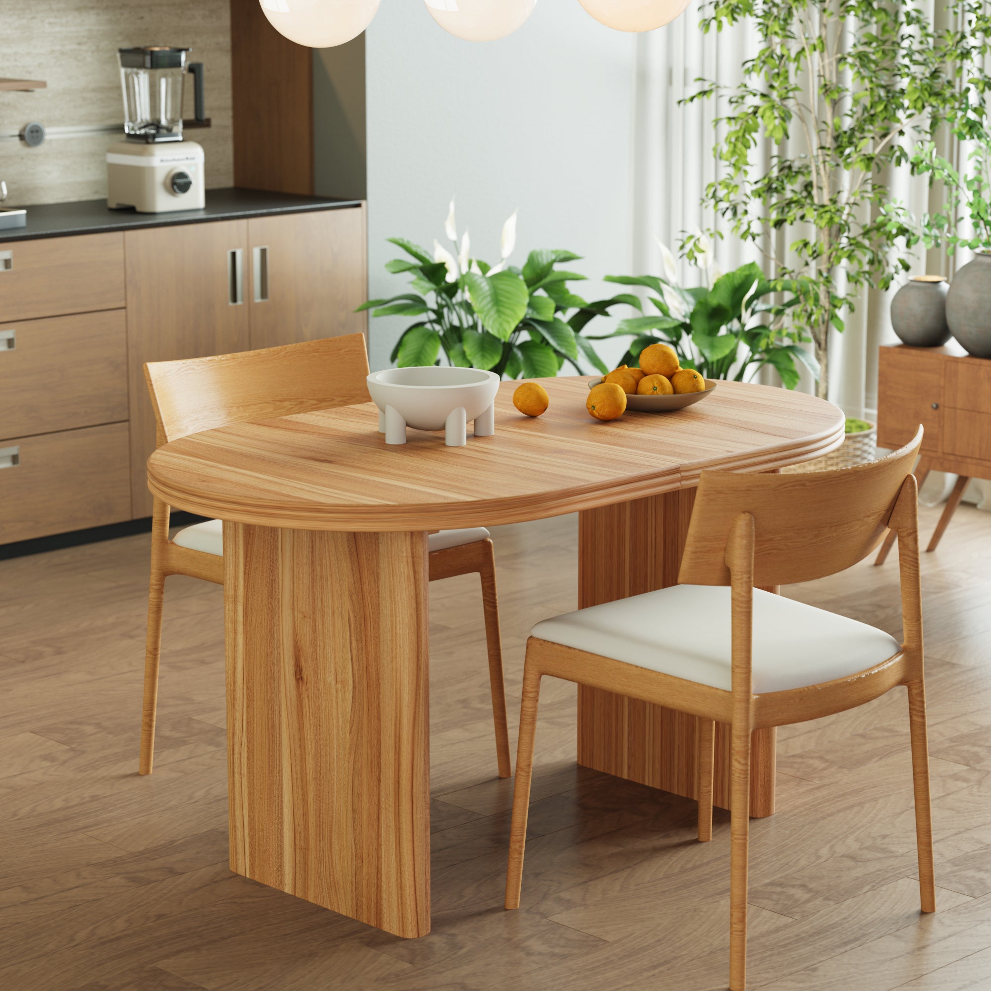 Three-quarter view of the extended walnut-tone oval table with oranges and greenery