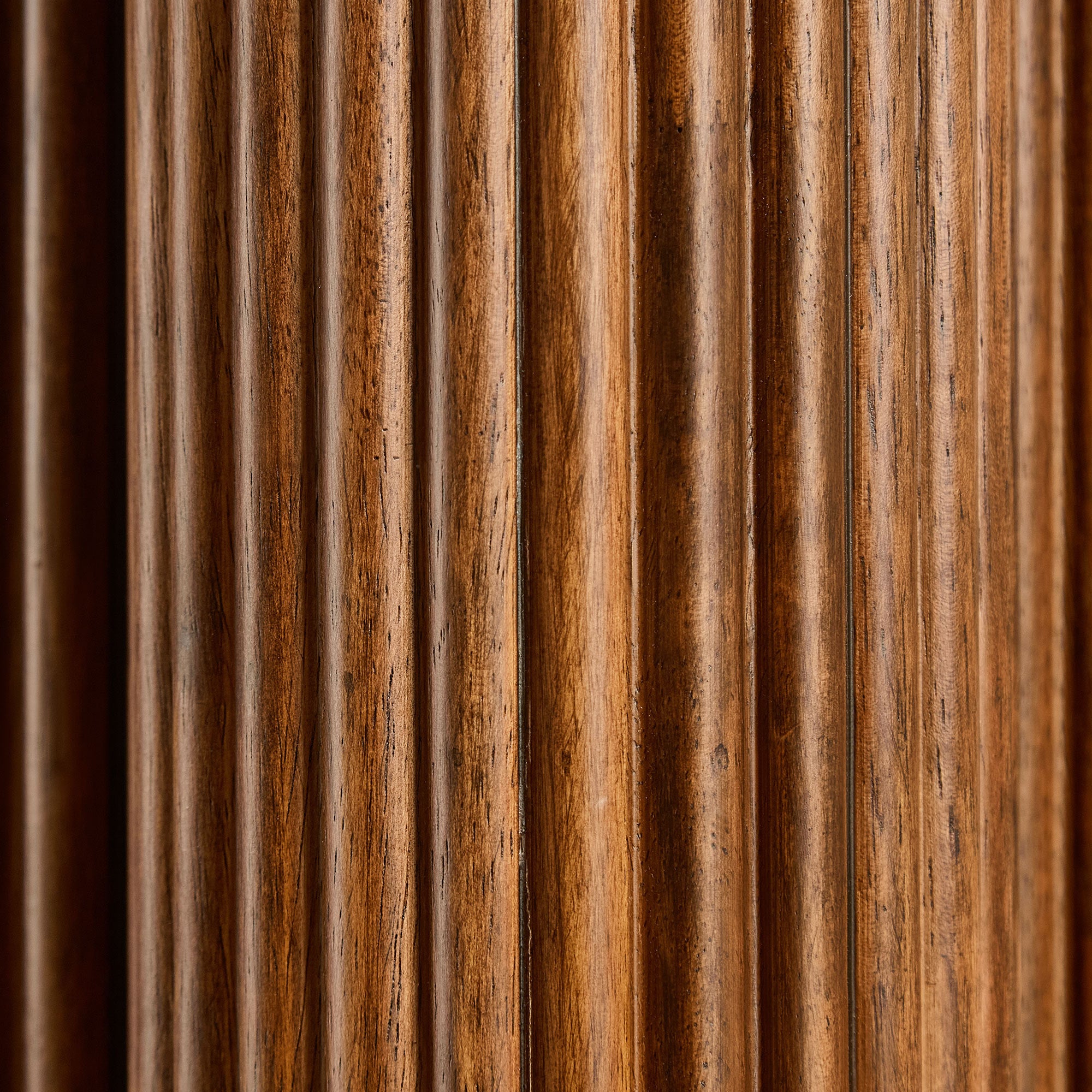 Extreme close-up of the vertical fluted grooves on the walnut column