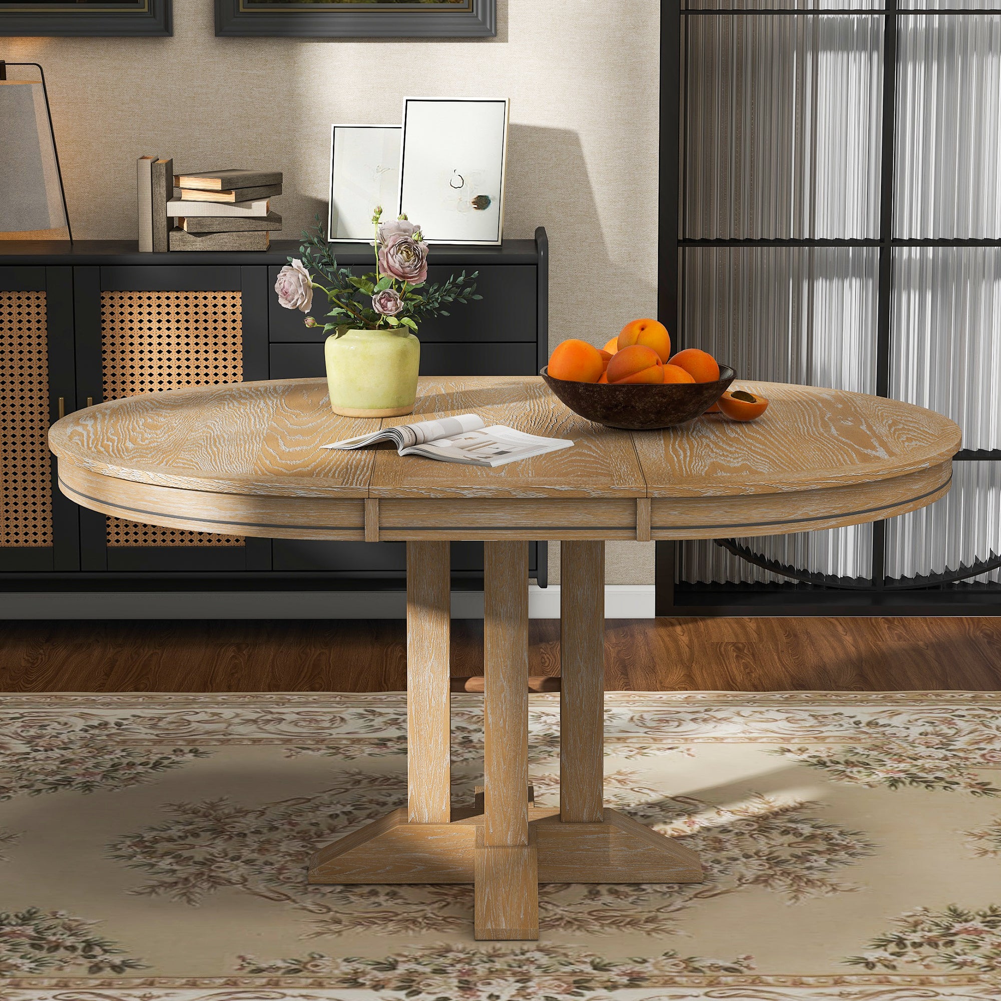Natural oak farmhouse dining table extended to an oval, three-quarter view in a styled room