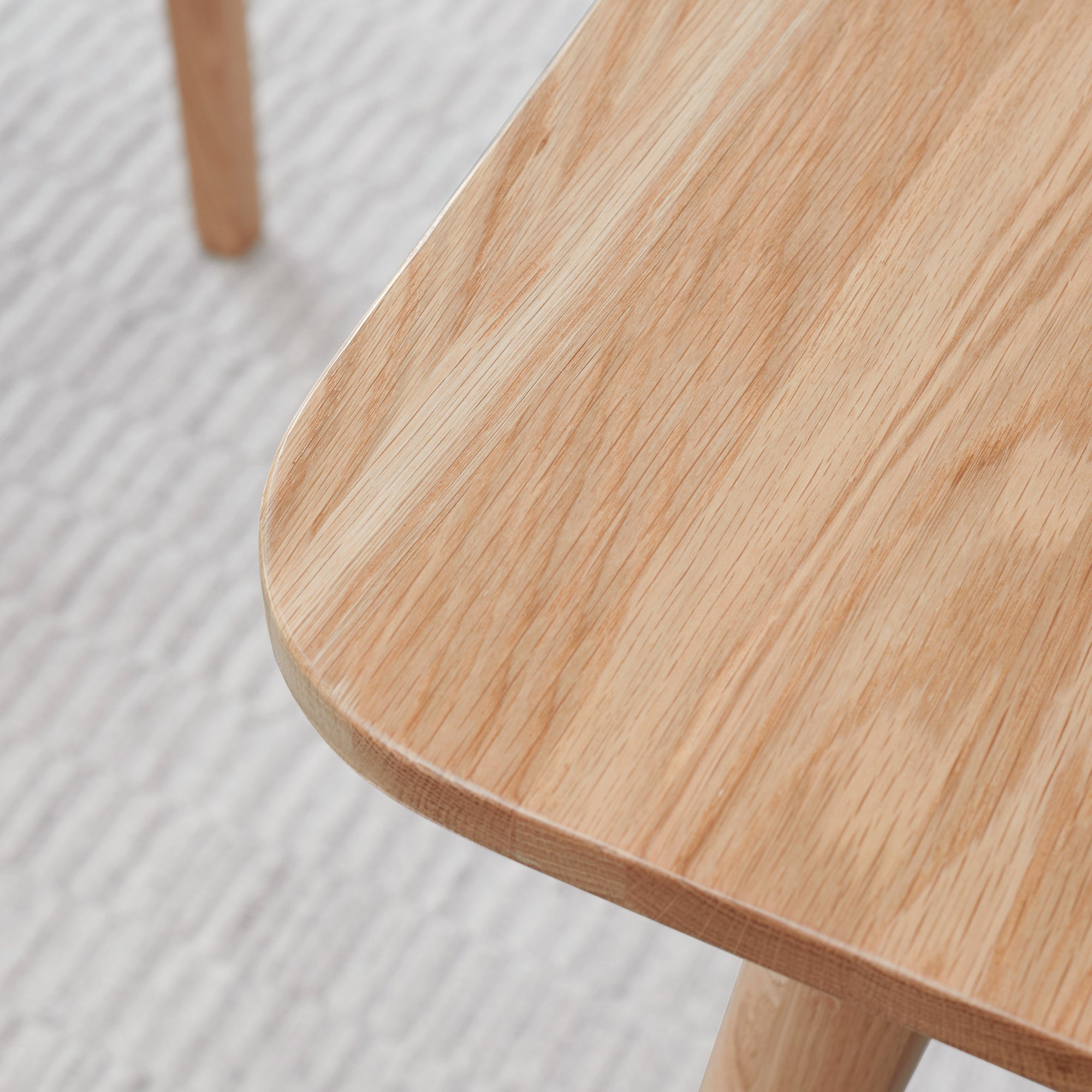 Close-up of the rounded corner of the natural oak tabletop