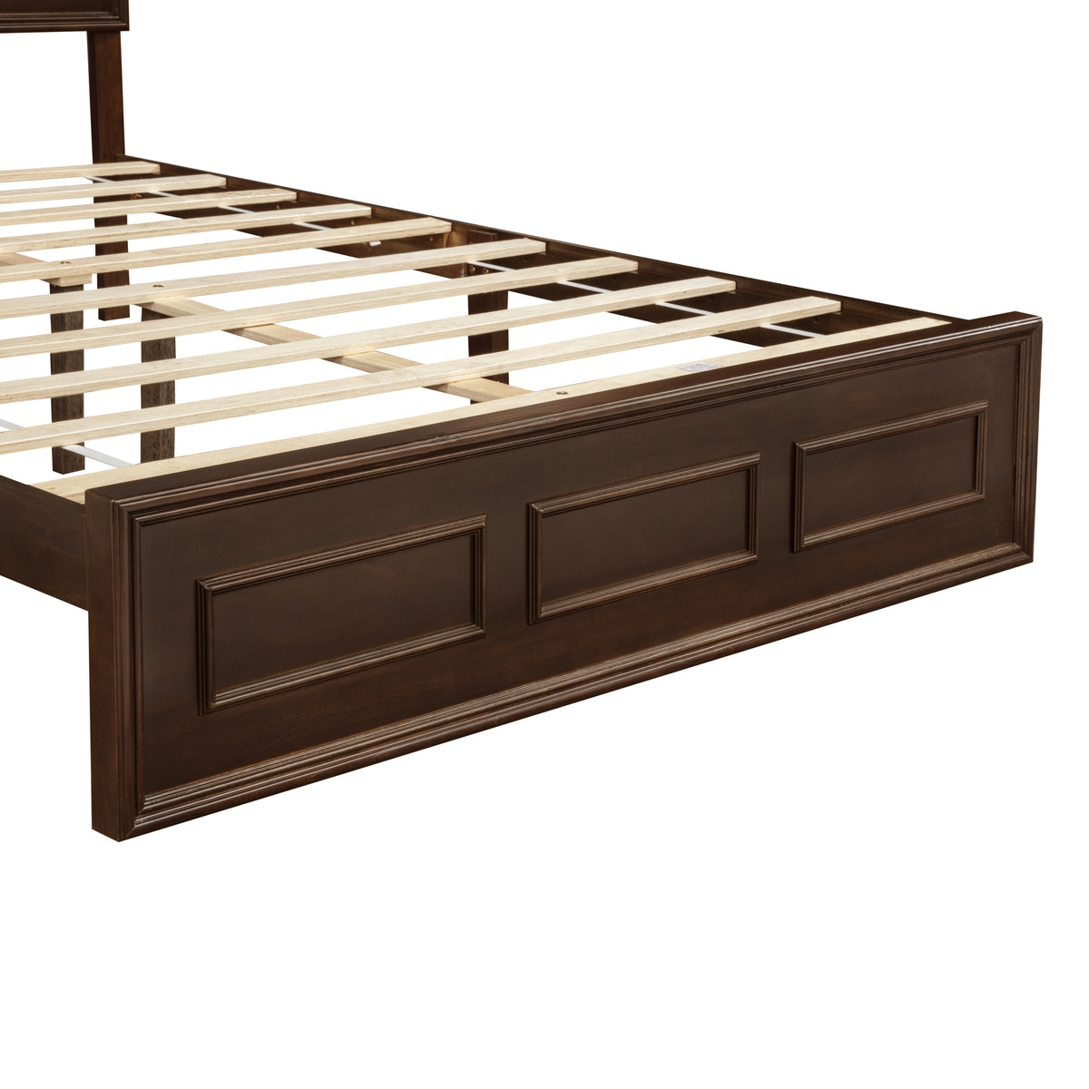 Angled view of rich brown queen footboard with recessed panels and wood slats