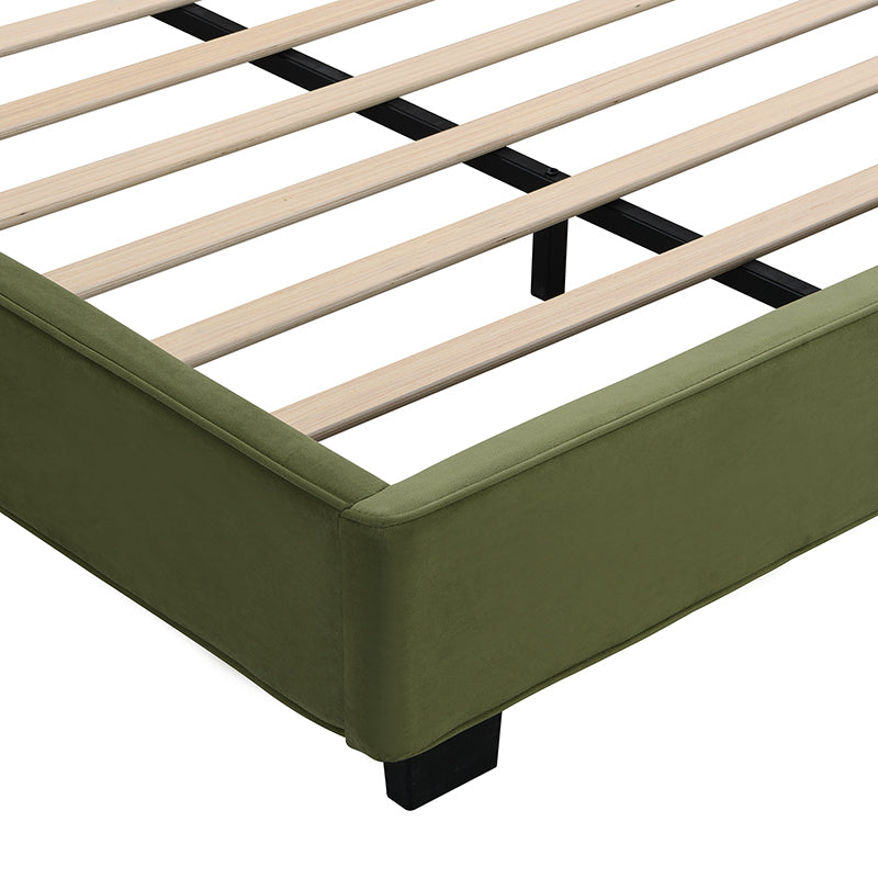 Close-up of upholstered corner seam and block foot on olive velvet frame