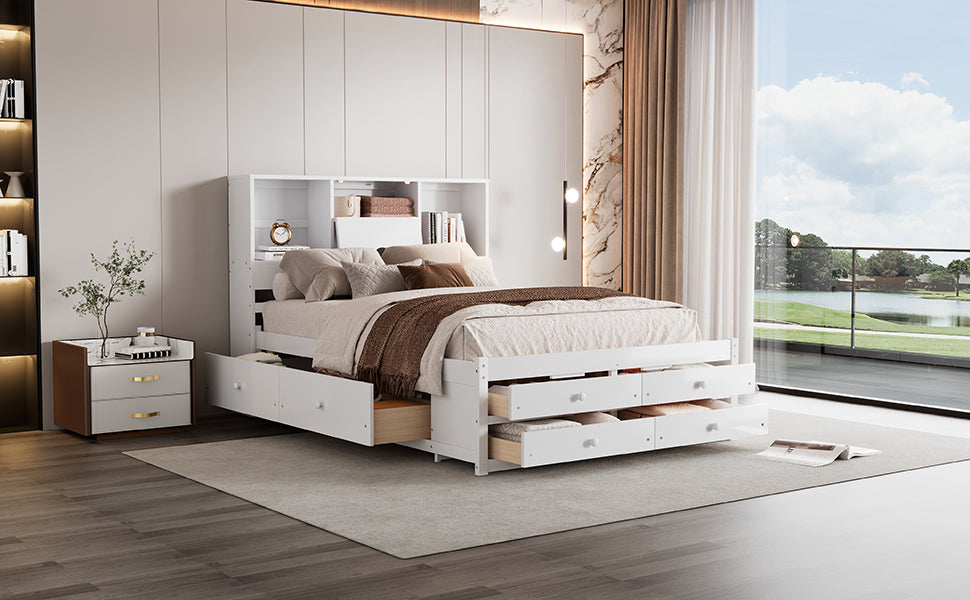 Angled view of the white storage bed with footboard drawers open and headboard shelves styled with books