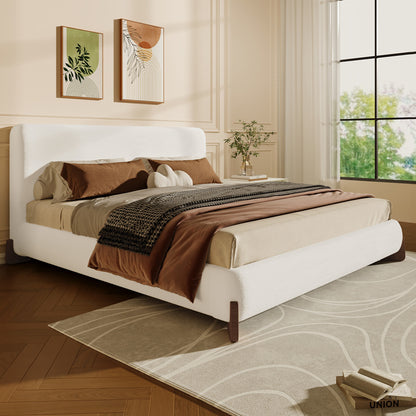 White bouclé king bed frame styled in a bedroom with brown throw pillows
