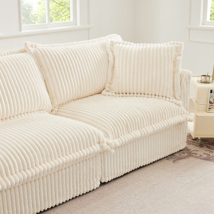 End of fluffy cream corduroy sectional highlighting overstuffed pillows, soft ribbed fabric, and cozy armrest detail.