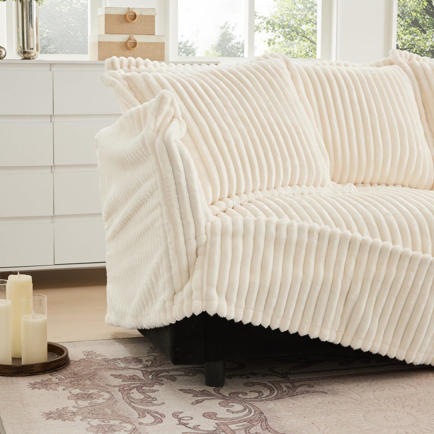 Detail view of fluffy cream sectional showcasing removable, machine washable slipcovers being lifted for easy care and maintenance.
