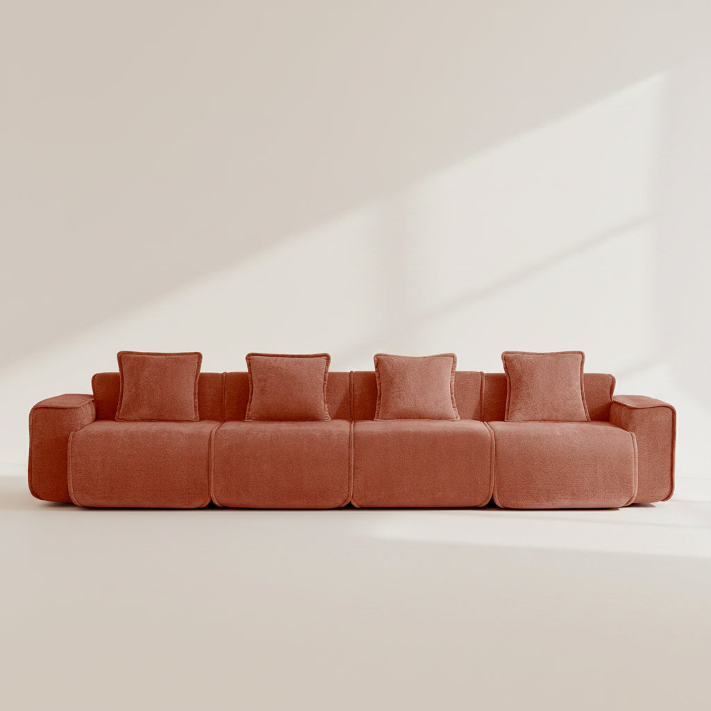 Studio shot of the seneca boneless couch showing four seats rich terracotta hued velvet upholstery