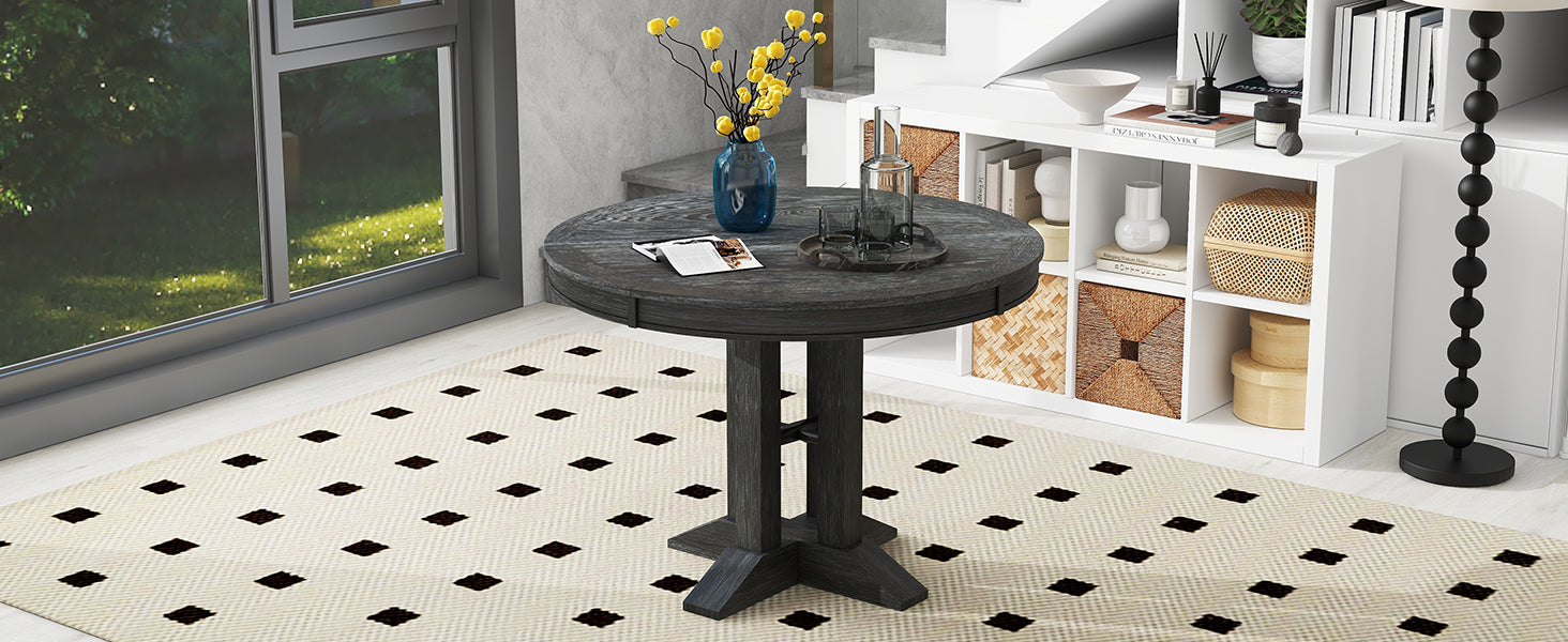 Black round dining table unextended, styled in a bright living space