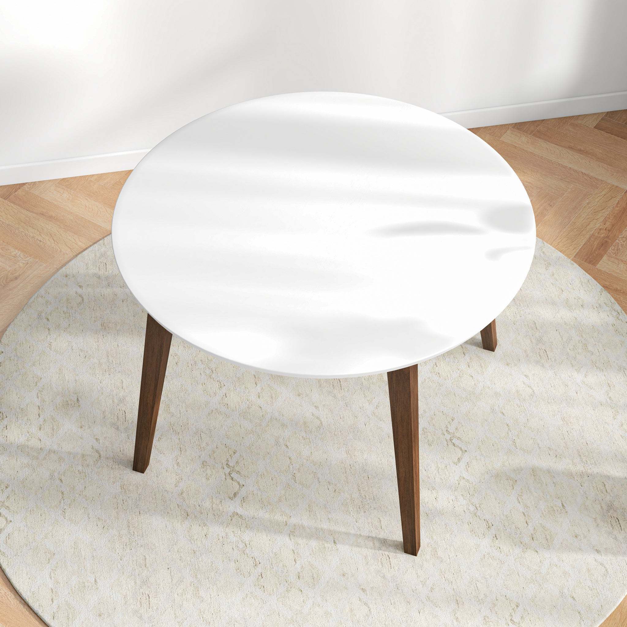 Overhead angled view of the white round dining table in a styled room