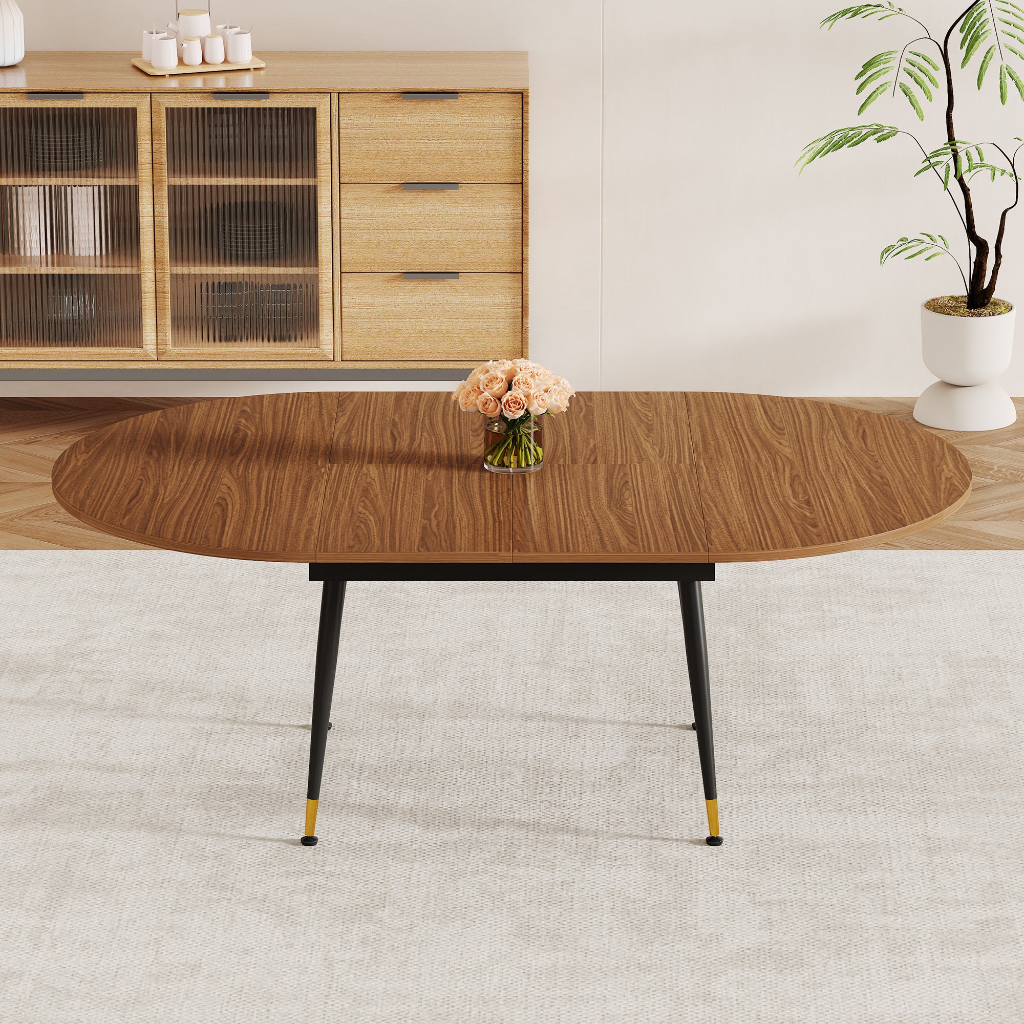 Walnut table in round setting with five brown suede chairs, roses and a book on top