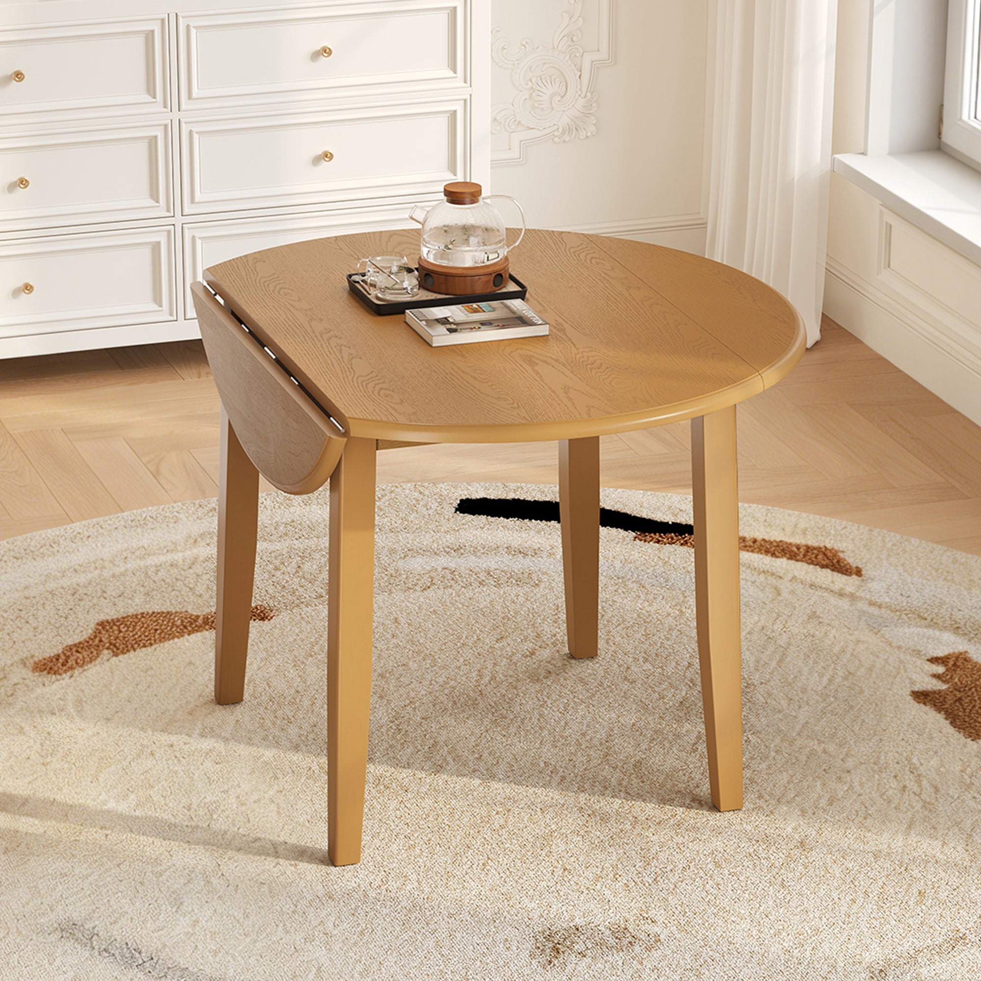 Styled room with the light brown folding round table, one drop leaf folded down and a teapot on top