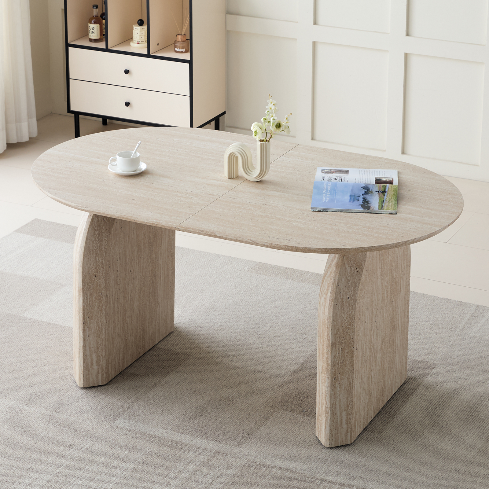 Off-white oval extendable dining table styled beside a sideboard by a window