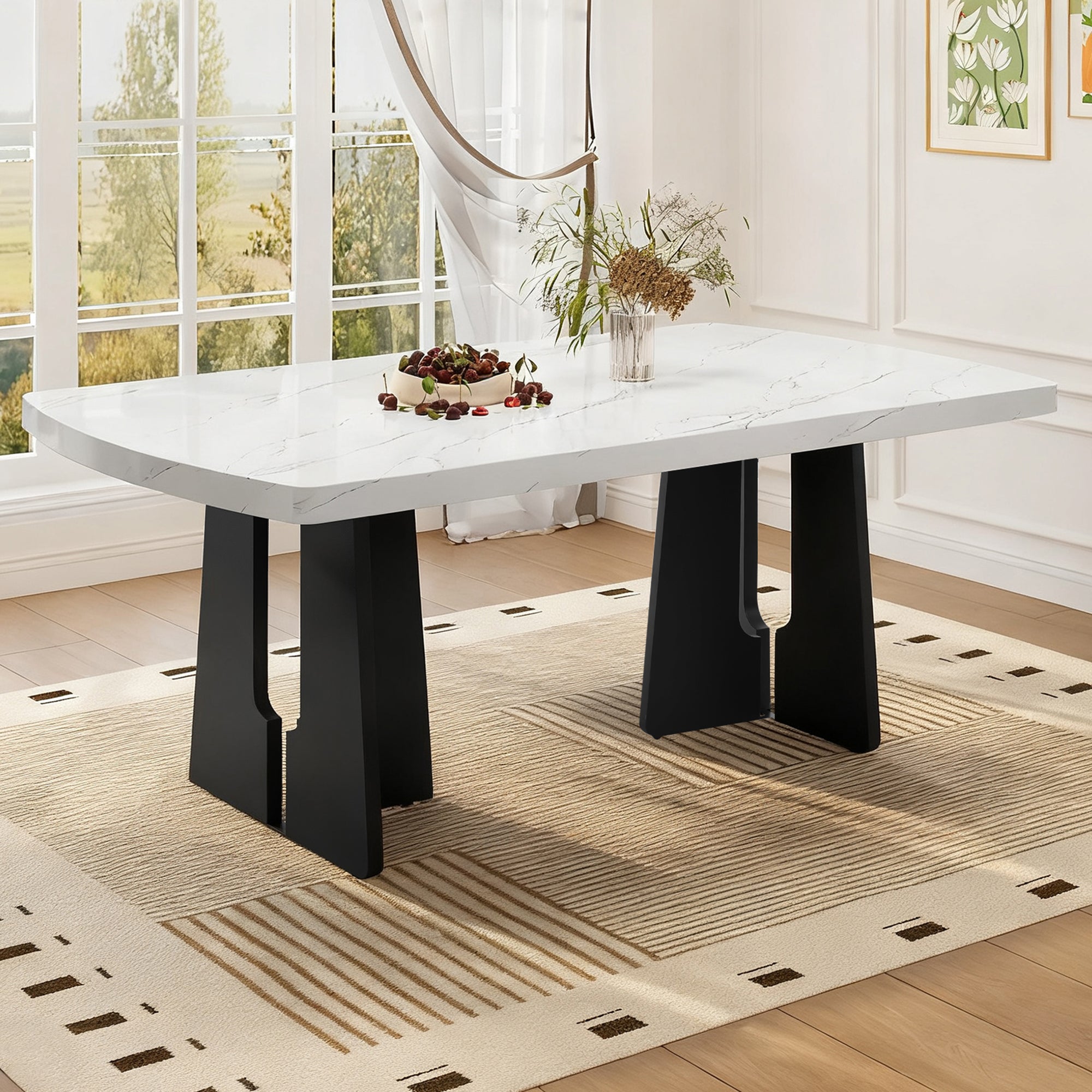 Faux marble dining table with black geometric legs styled in a bright room with cherries and flowers