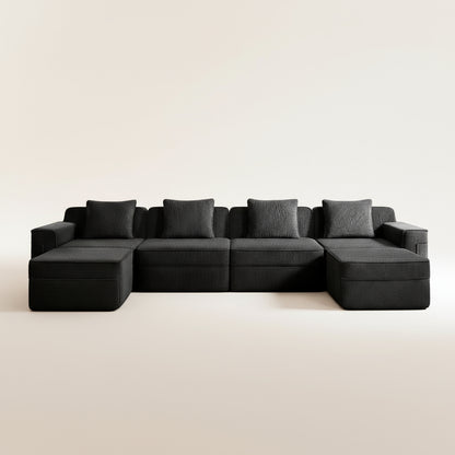 studio shot of the boneless couch in black corduroy showing the texture of the upholstery, four deep seats and two ottomans