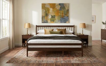 Wide bedroom shot of walnut king bed with two lamps