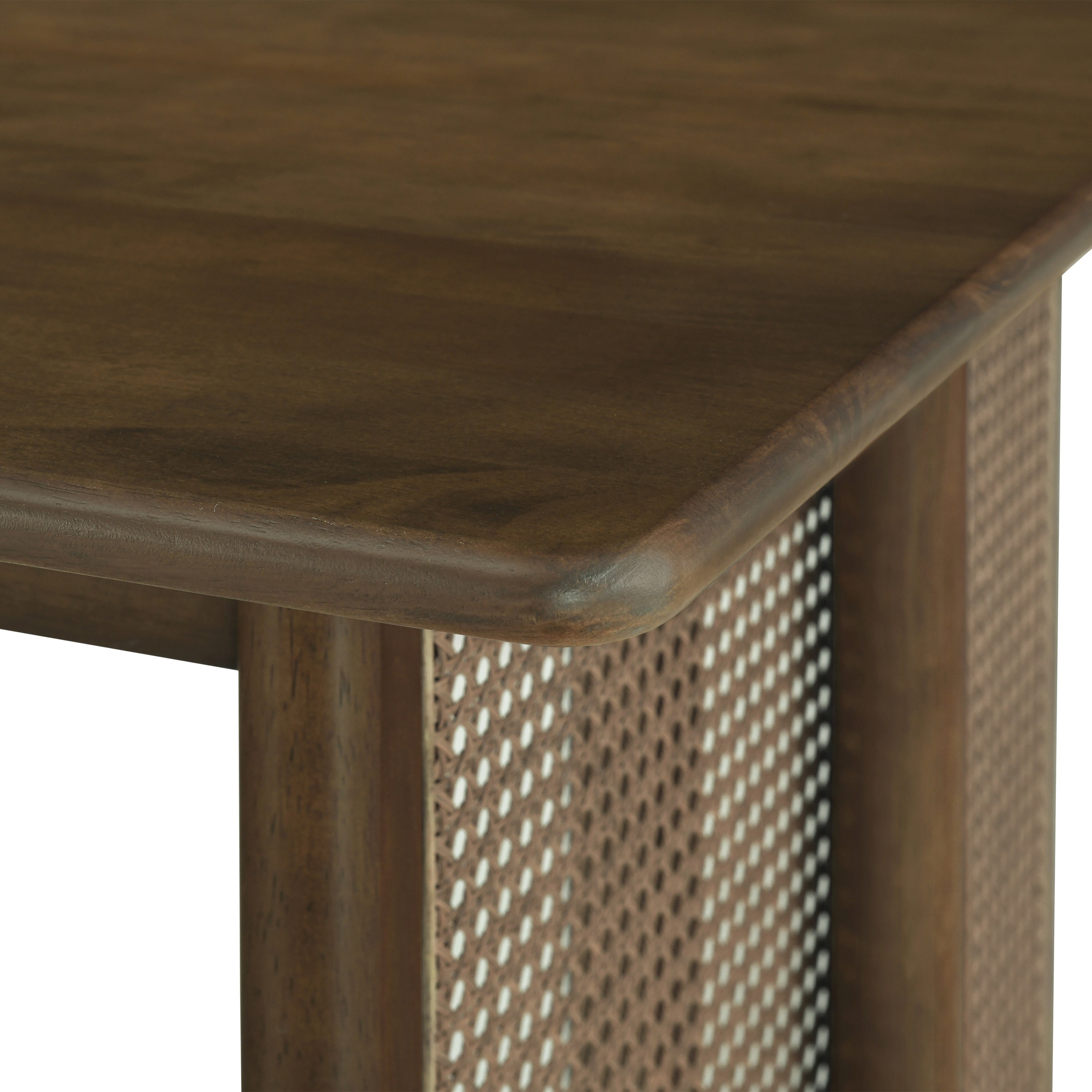 Close-up of a tabletop corner meeting the woven cane panel leg on the walnut dining table, white background
