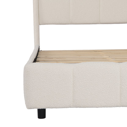 Close-up of footboard corner showing beige bouclé fabric and black support leg