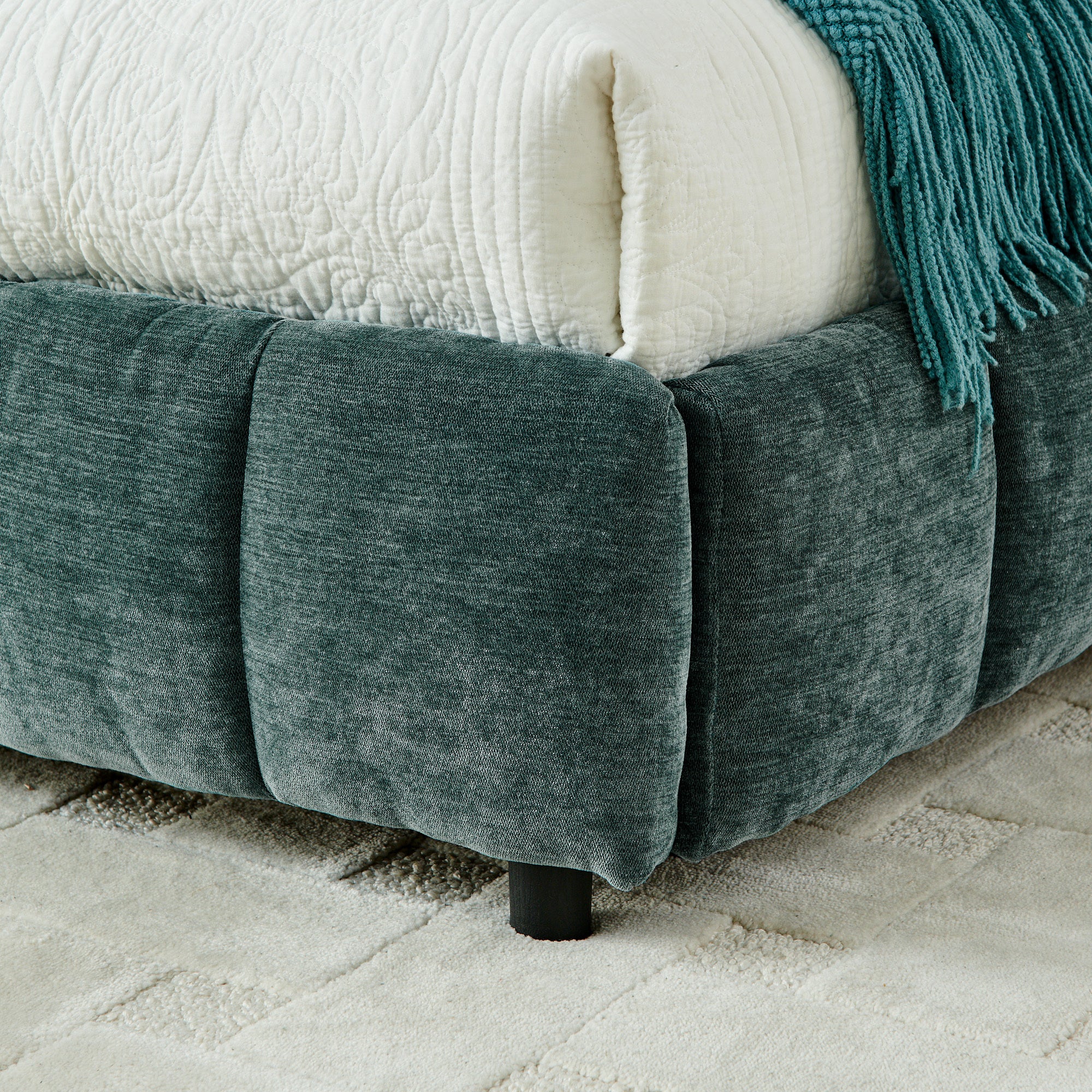 Open underbed storage drawer with pillow and folded throw inside