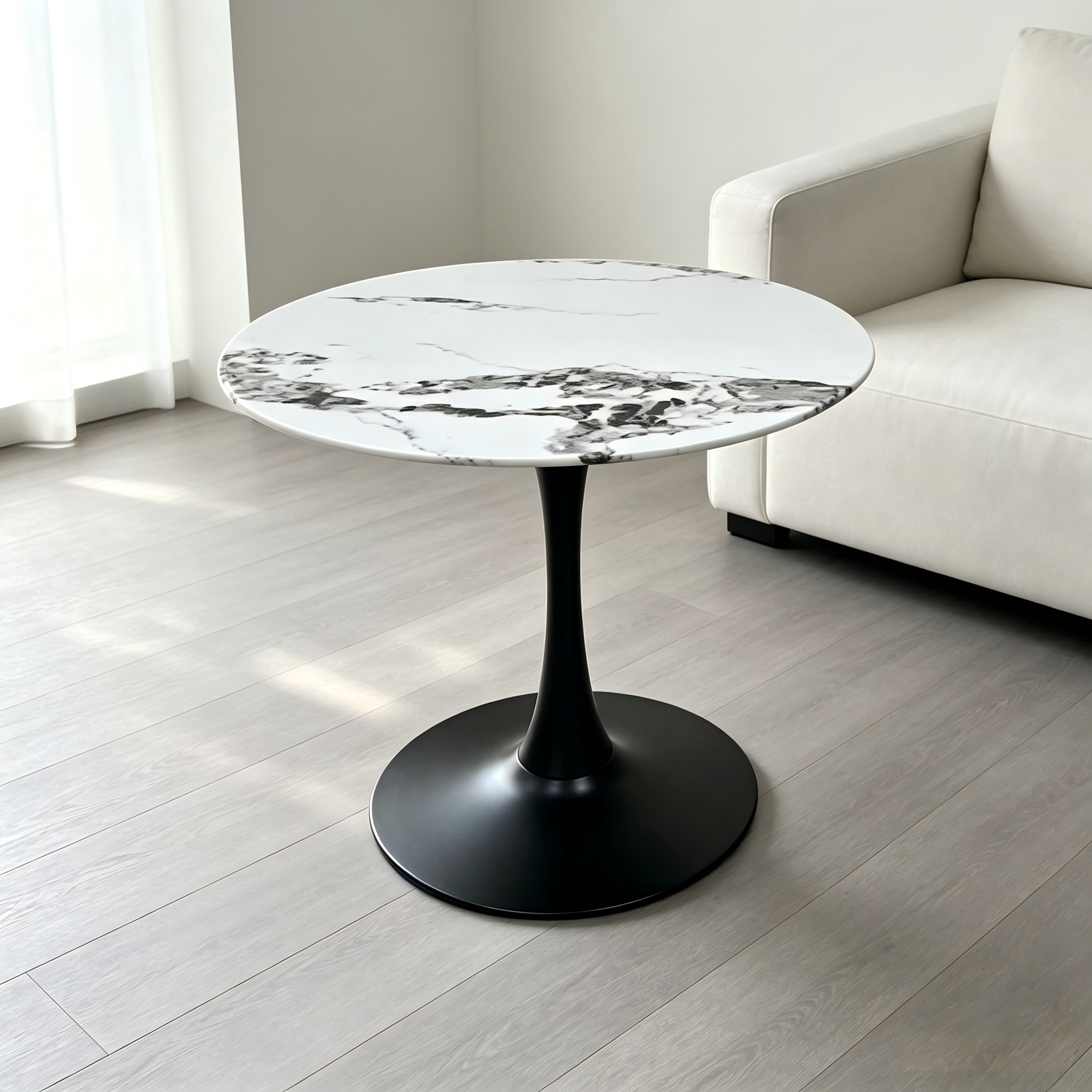 Faux marble tulip dining table with black pedestal beside a sofa in a living room
