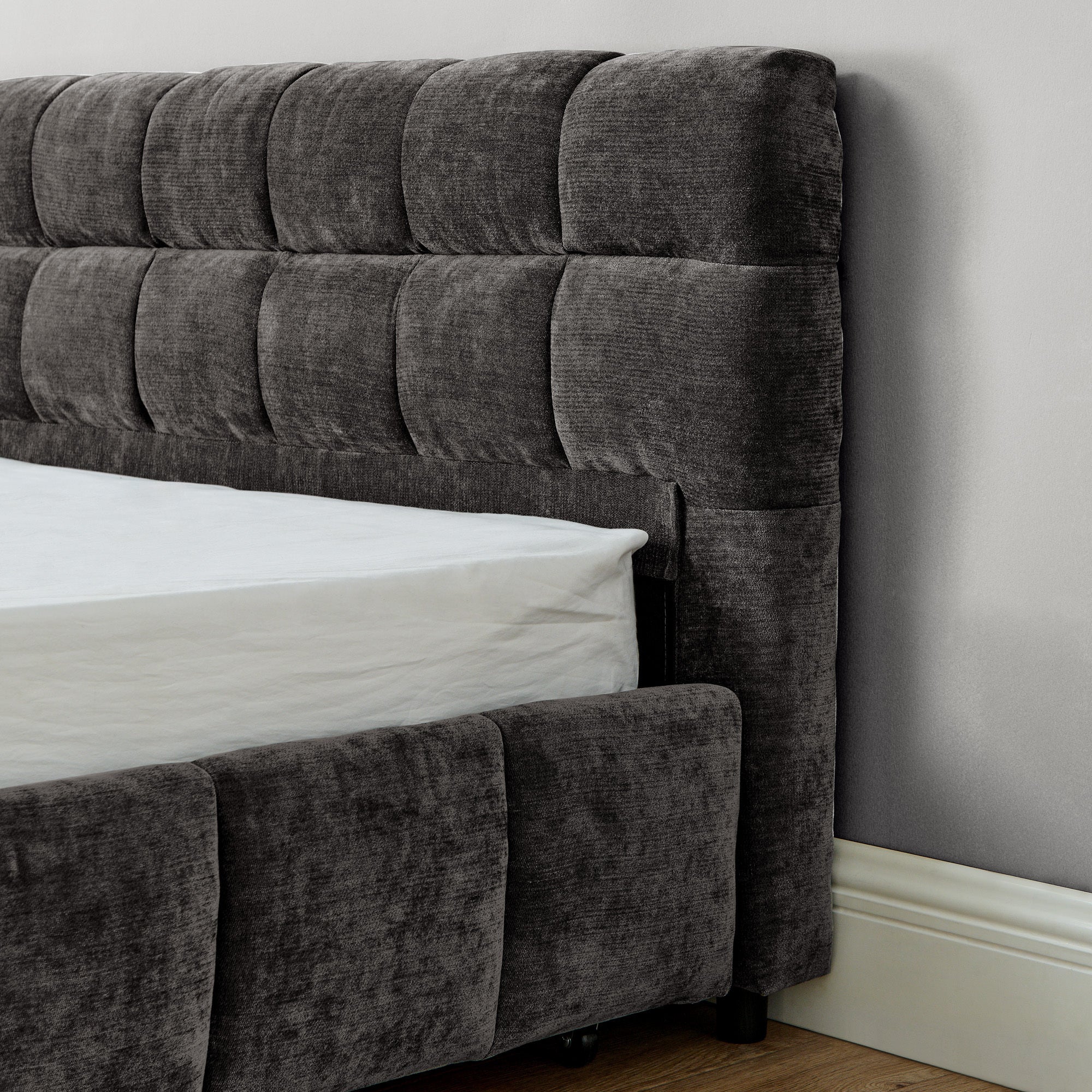 Close-up of caster wheel on storage drawer, dark gray king bed frame
