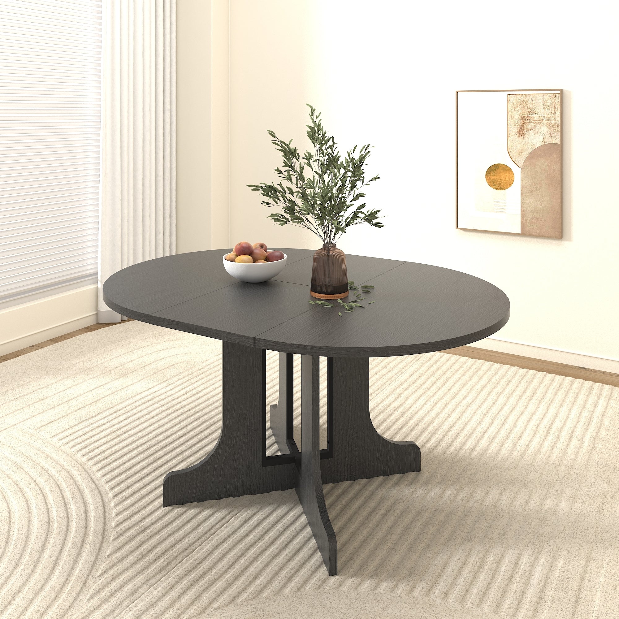 Round black dining table with a fruit bowl and vase in a paneled corner with abstract art