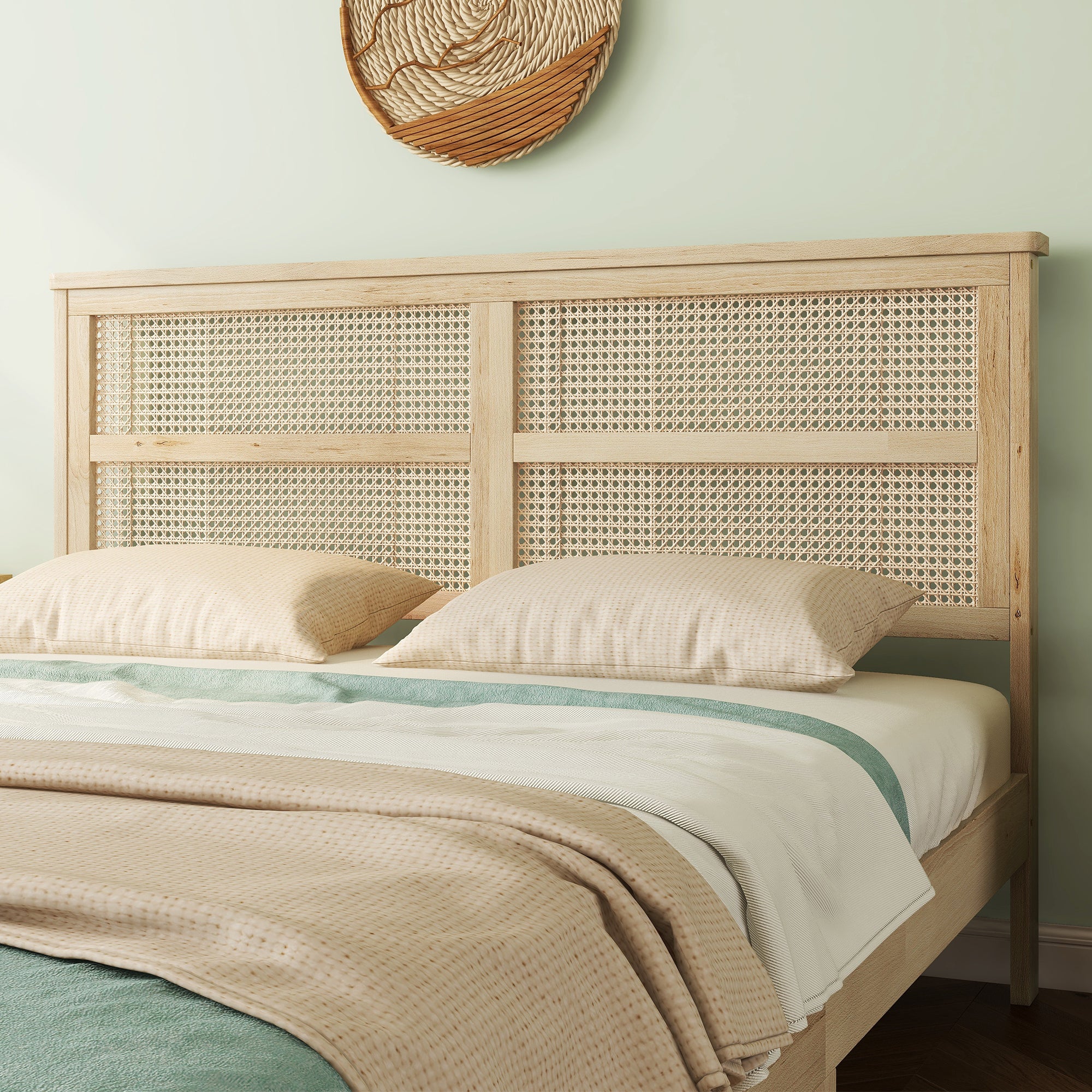 Close-up of the two-panel woven rattan headboard on the queen wood bed frame against a soft green wall