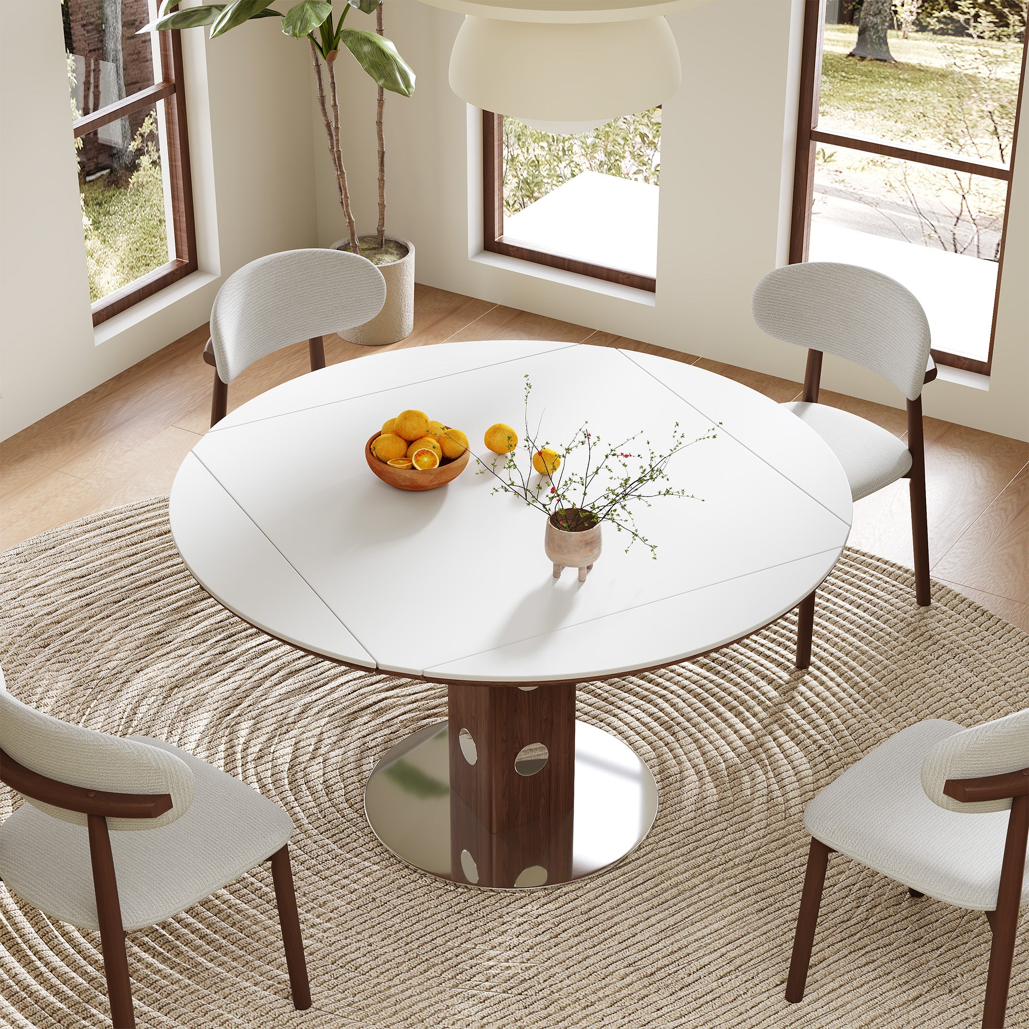 Overhead view of white sintered stone round folding dining table with walnut column and cream chairs