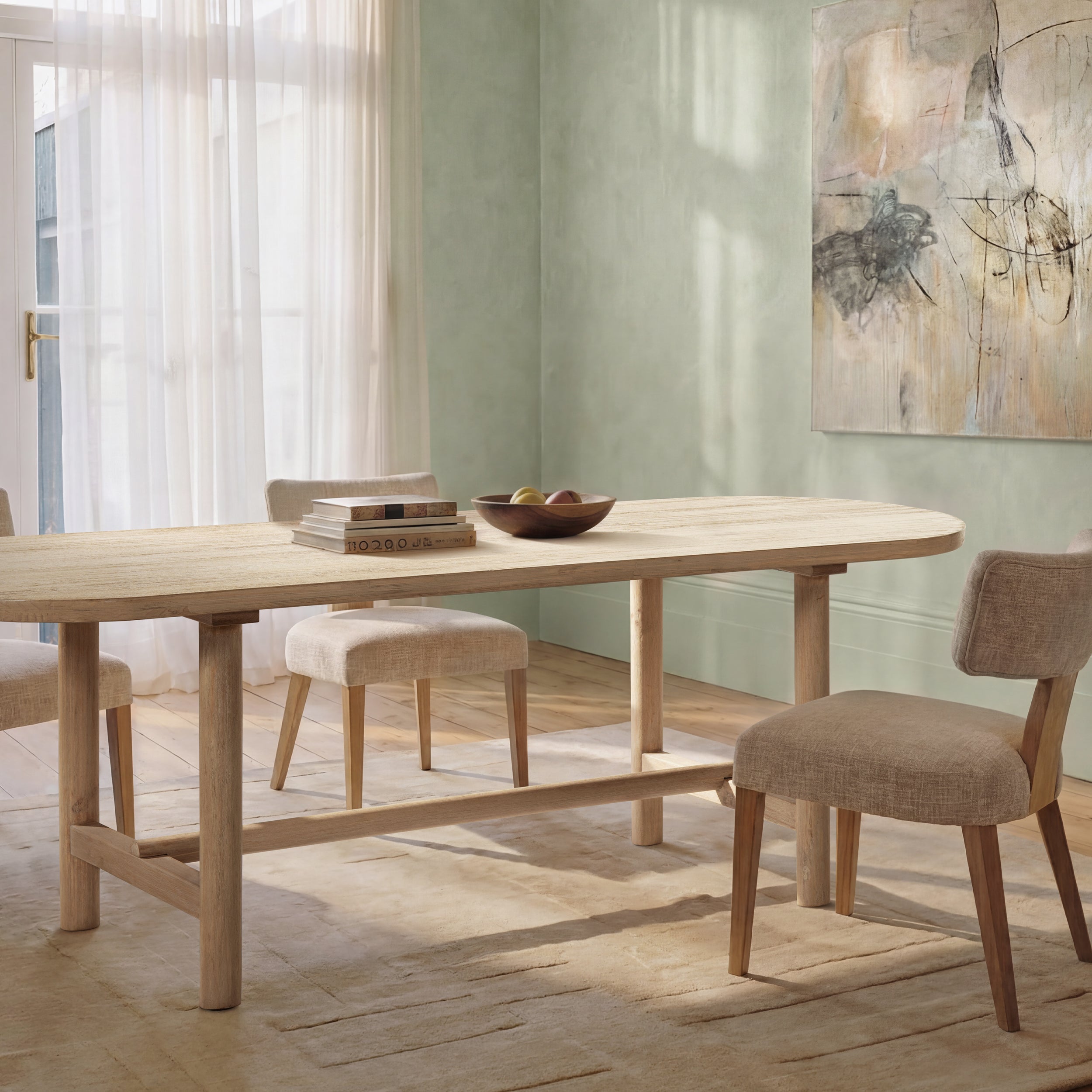Cerused pine oval dining table styled with chairs in a sage green dining room