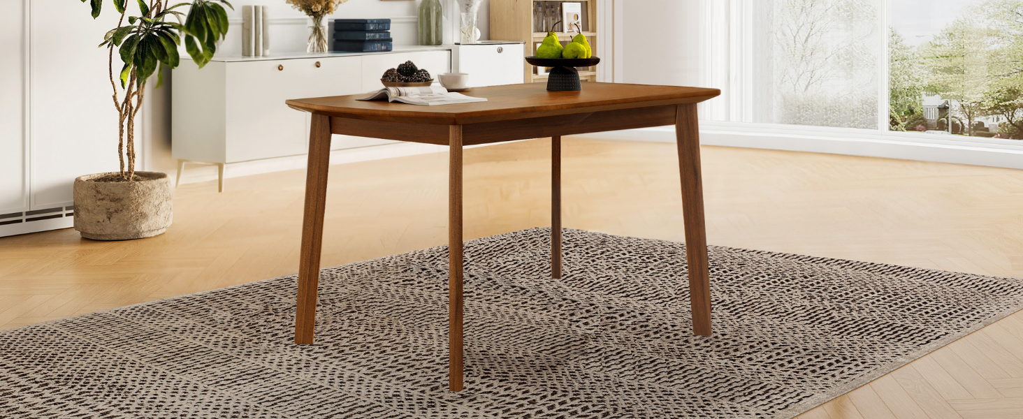 Brown mid-century dining table with fruit and magazine styled beside a plant and window