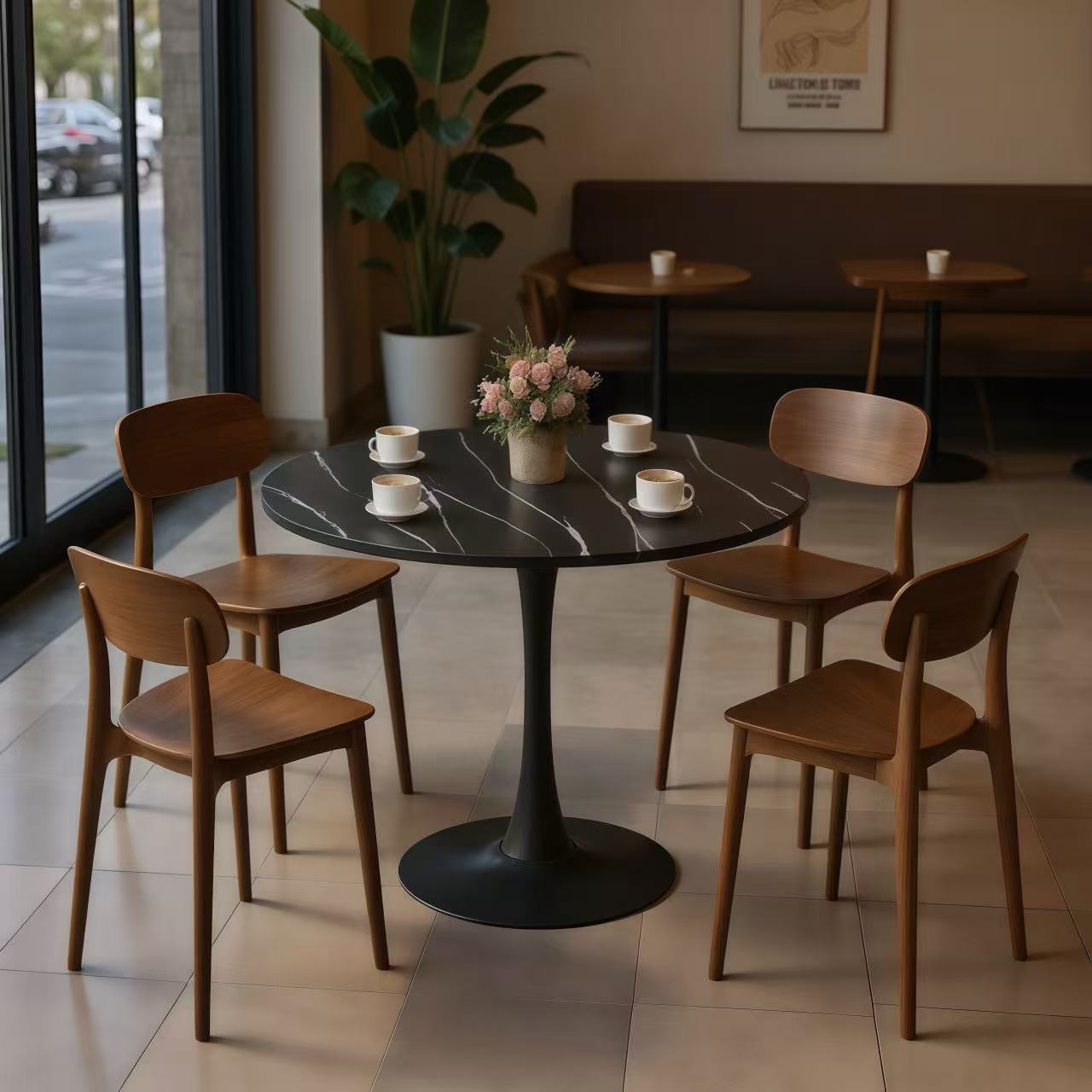 Black marble round bistro table set with four wood chairs in a cafe seating area