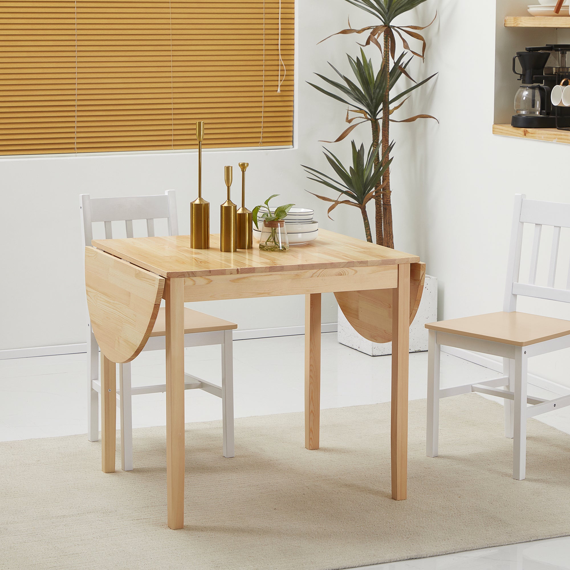 Natural pine table with one leaf folded down into a square, styled dining setting with gold candlesticks