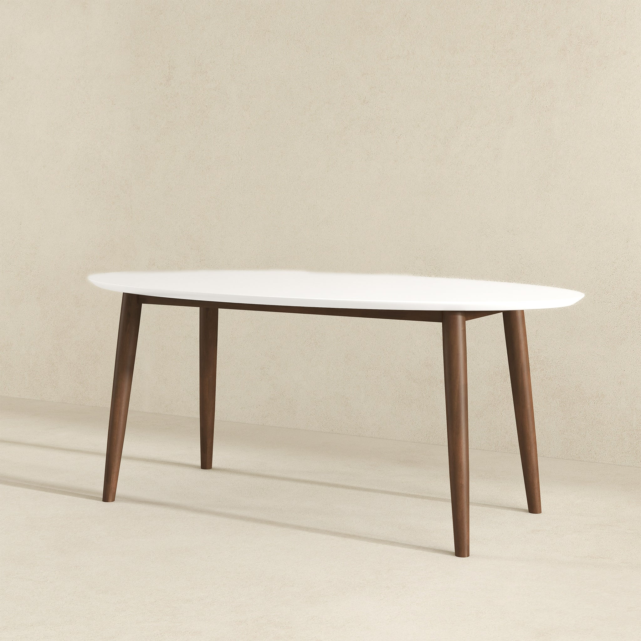 White-top oval dining table with walnut legs, three-quarter view in a styled room