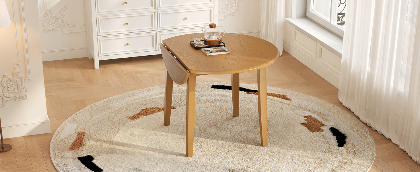Angled styled room view of the light brown round table with a drop leaf folded