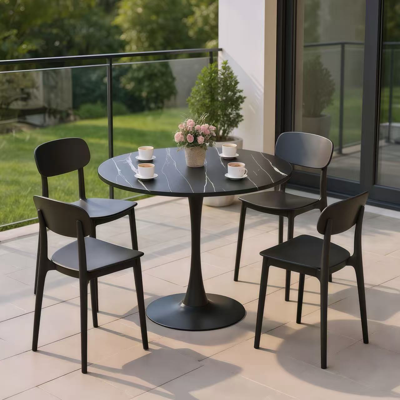 Black marble round bistro table with four black chairs on an outdoor balcony
