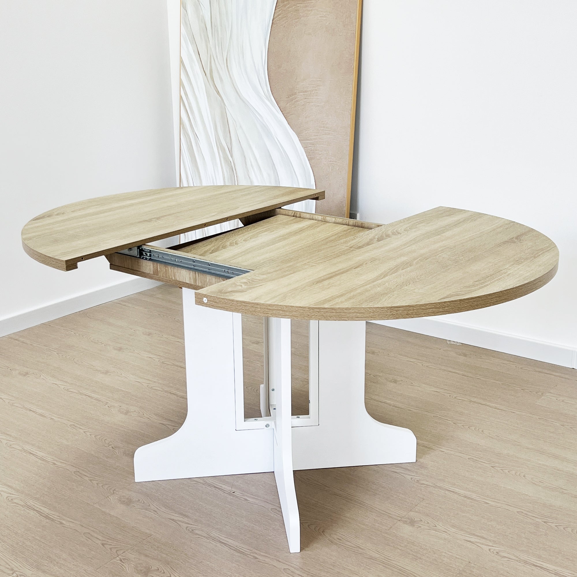 Oak-top table with white base split open, the folding leaf and slide rail exposed at the center