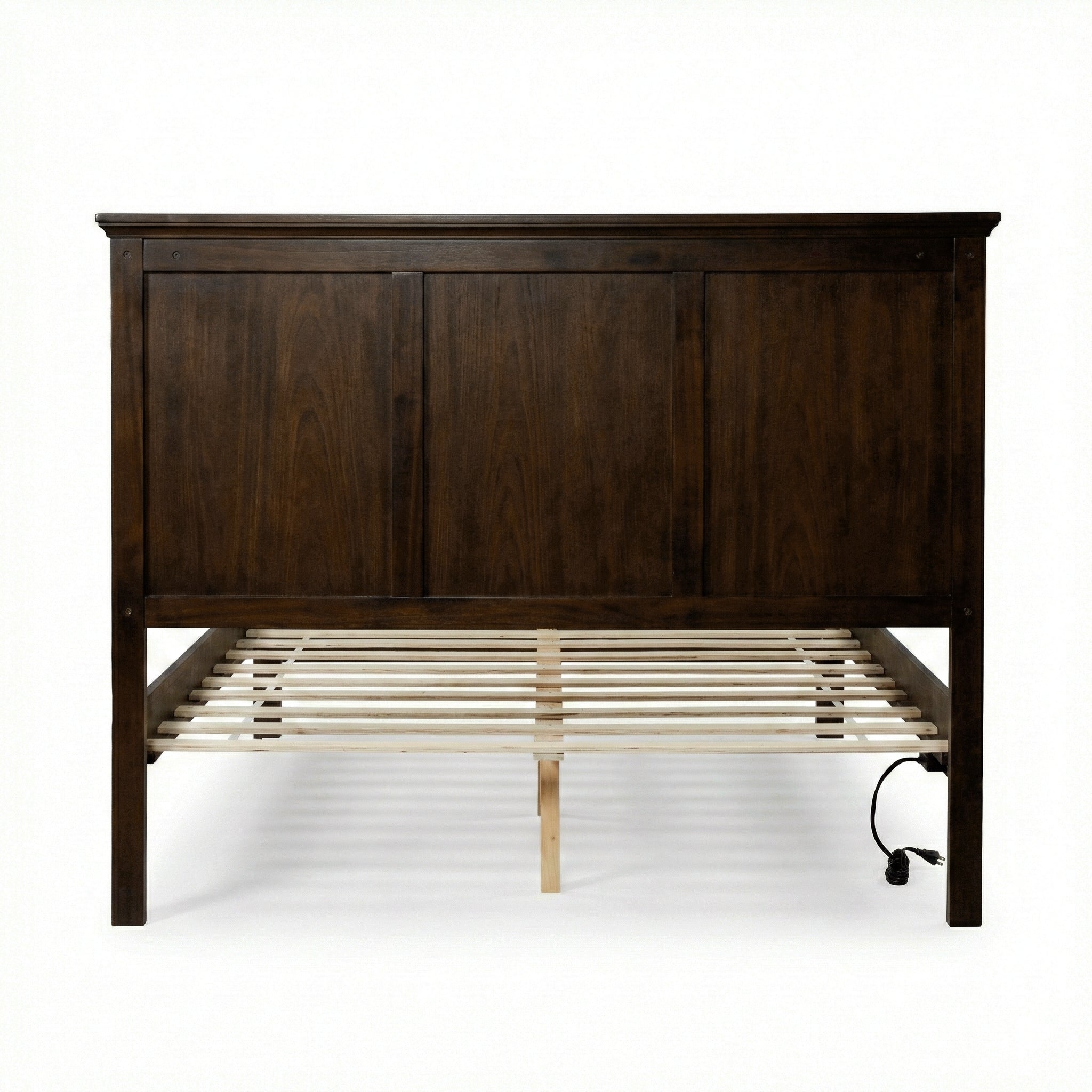 Close-up of the molded top rail and crown on the brown panel headboard of the queen bed