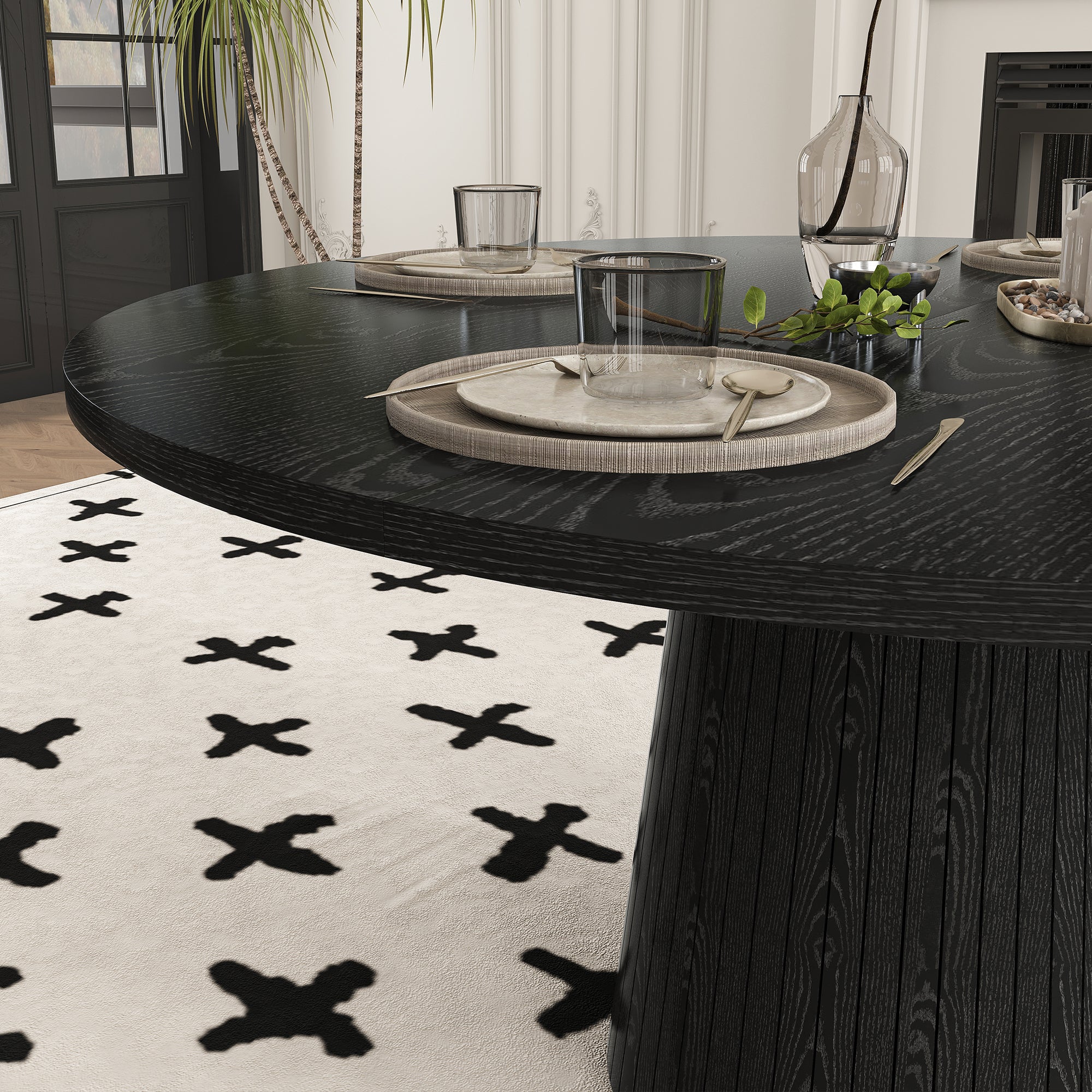 Close-up of the black tabletop edge and a place setting with the pedestal base below