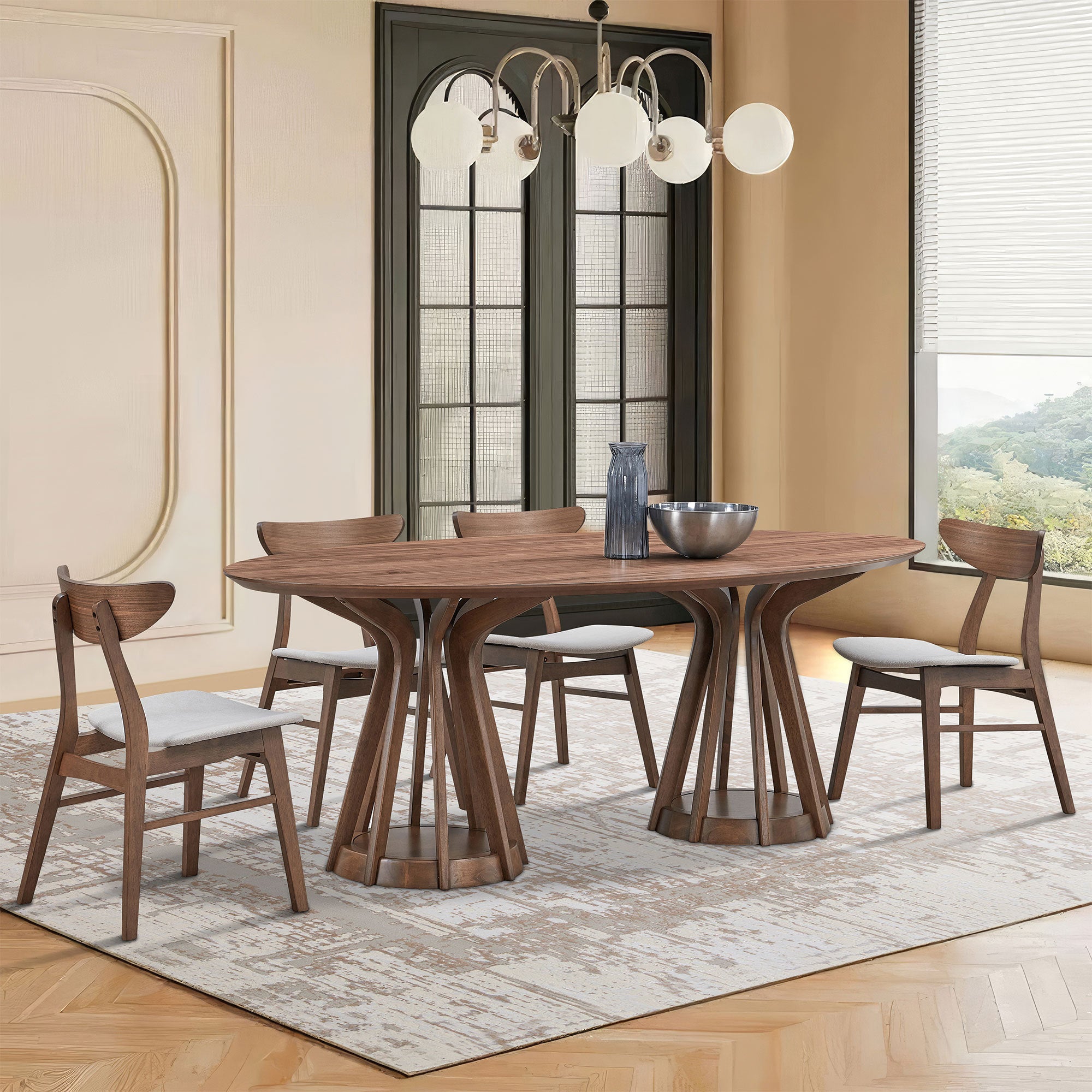 Walnut oval pedestal dining table with four chairs in a warm dining room