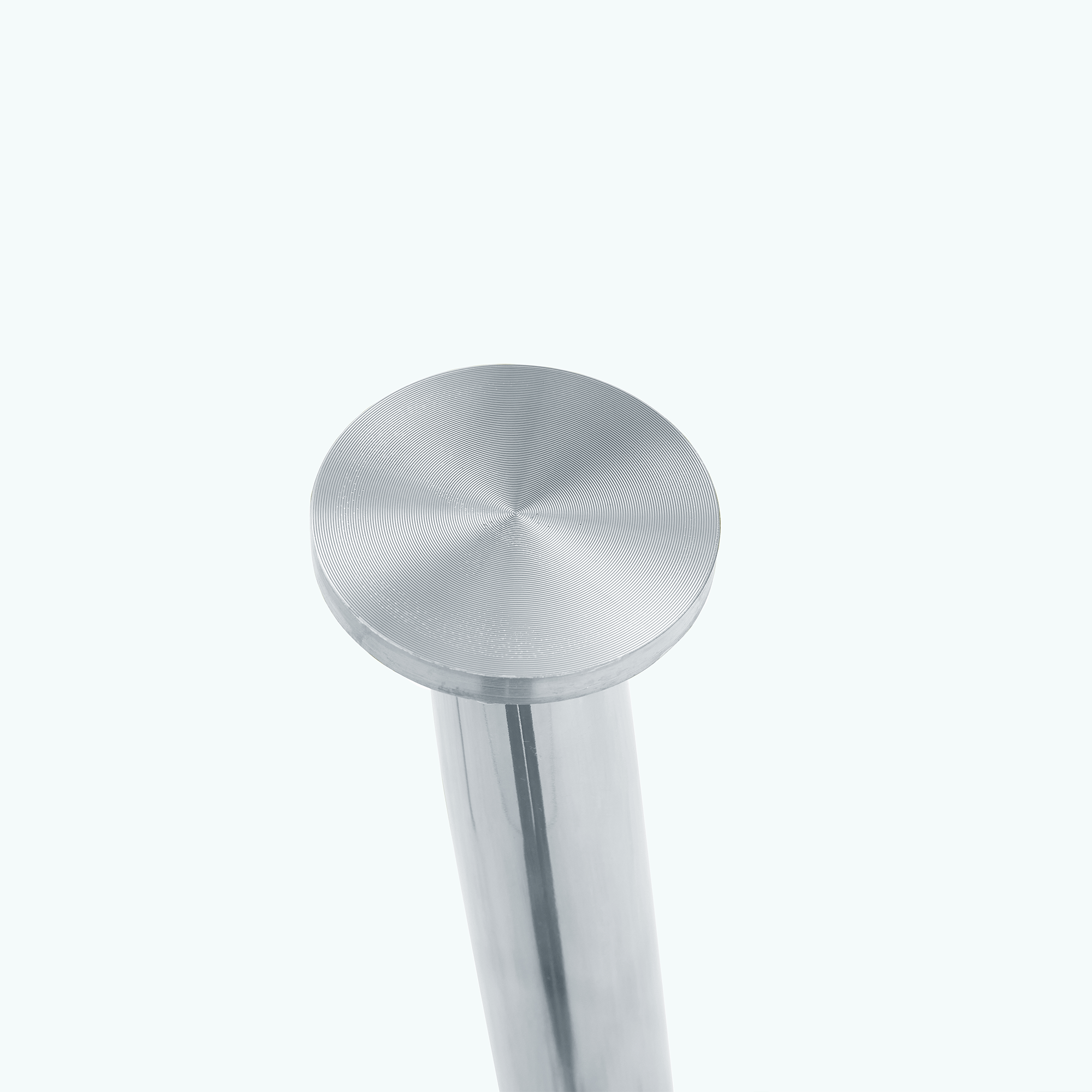 Studio close-up of a brushed metal suction-cup top on a chrome table leg