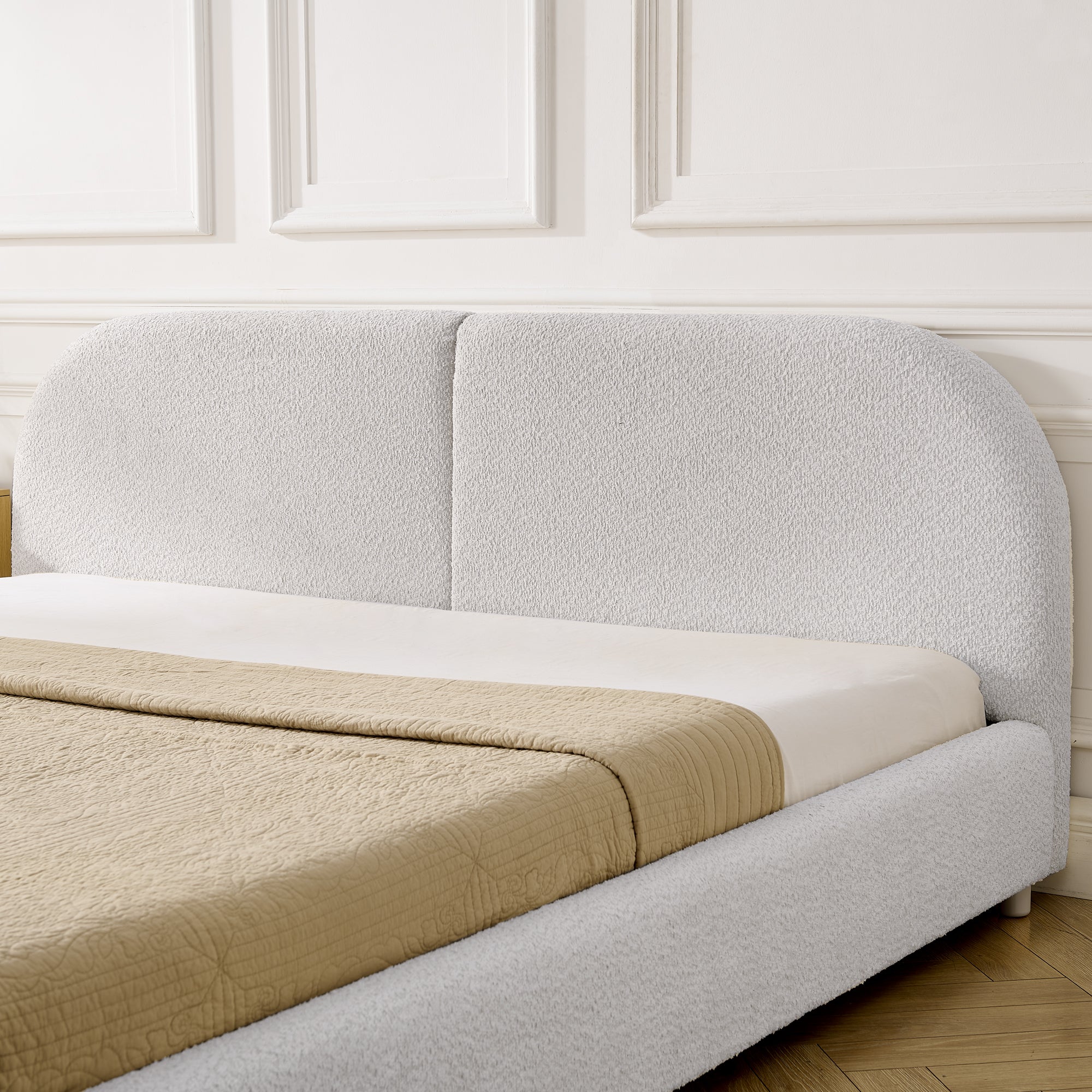 Close-up of curved beige headboard showing circle-yarn fabric texture