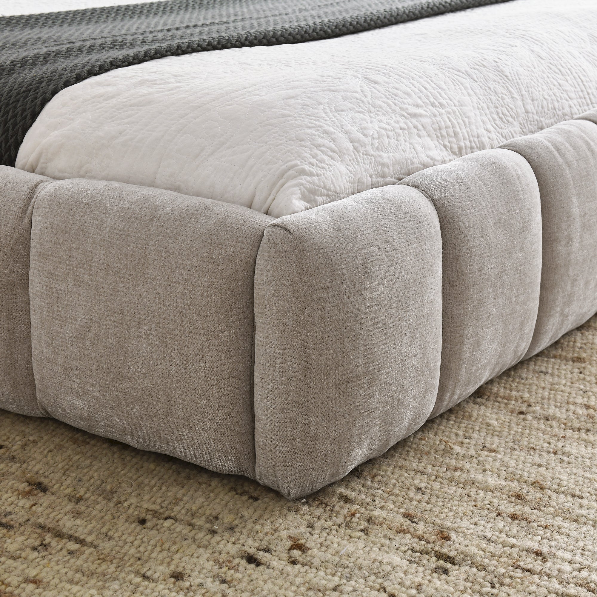 Close-up of the beige chenille bubble-tufted foot rail corner with white bedding #Color_Beige