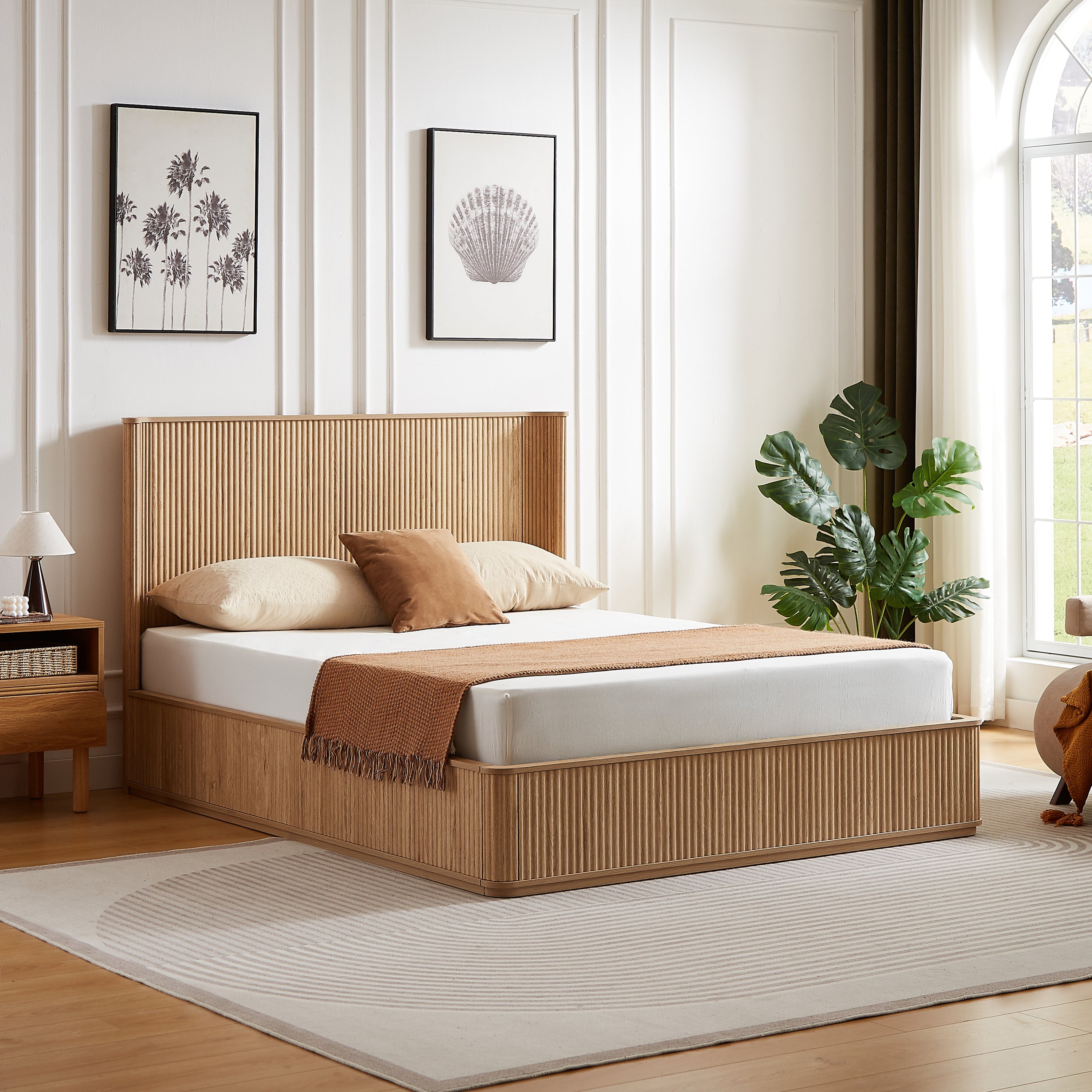Angled view of the natural oak fluted queen platform bed by an arched window with a monstera plant #Color_Natural Oak