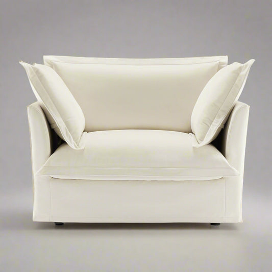 closeup shot of the big fluffy chair in cream chenille showing the plush pillows and rich upholstery texture as well as the wide and deep seat