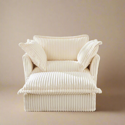 closeup of the fluffy chair in cream colored corduroy with an ottoman showing the ribbed texture of corduroy and plush seats backrest and pillows
