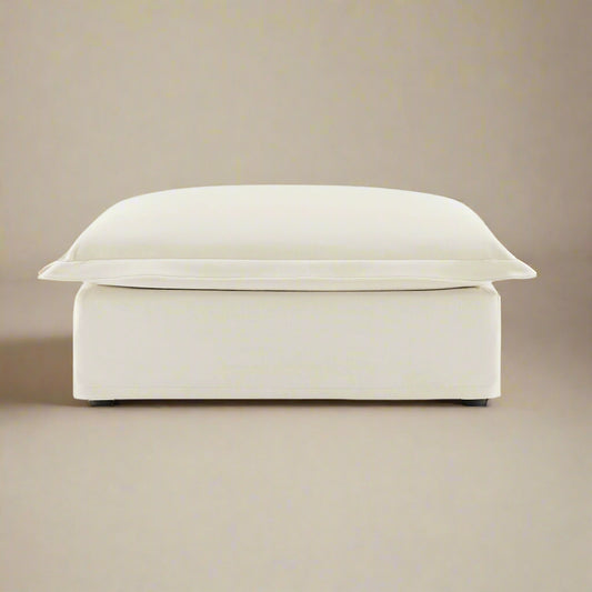 closeup shot of the fluffy ottoman in cream chenille showing the rich upholstery texture and color as well as the plush seat