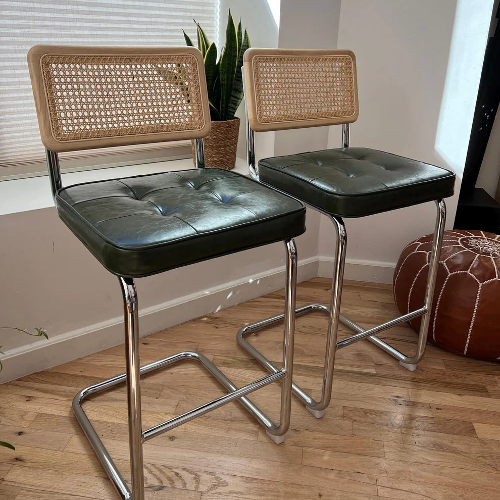 Mid-century modern 26-inch counter stool for 36-inch counter with green vegan leather seat, rattan backrest, and stainless steel fram