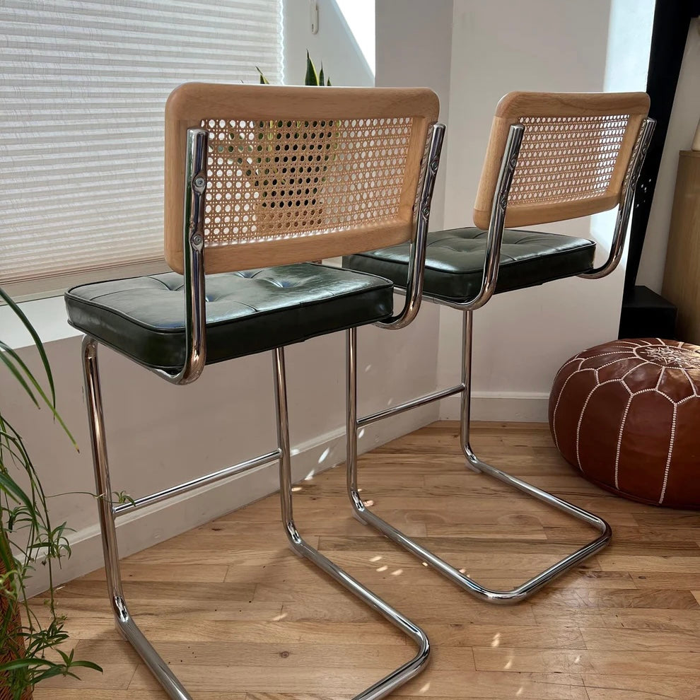 rear view of cantilevered 26 inch seat height counter stools with green vegan leather seats and stainless steel frames