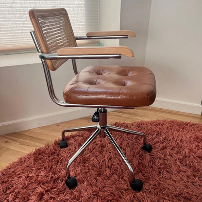 side profile view of mcm office chair with brown vegan leather seat and solid wood armrest and backrest
